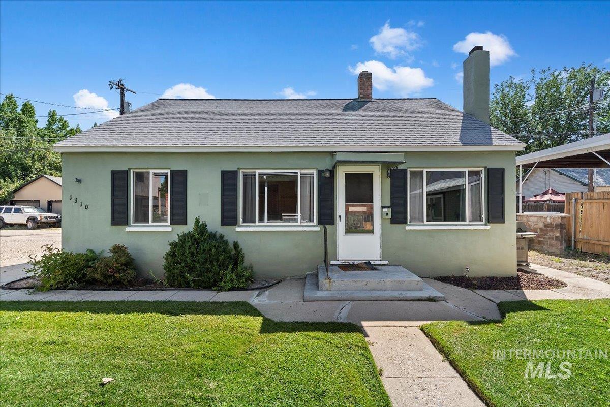 Bungalow-style house featuring roof with shingles, stucco siding.