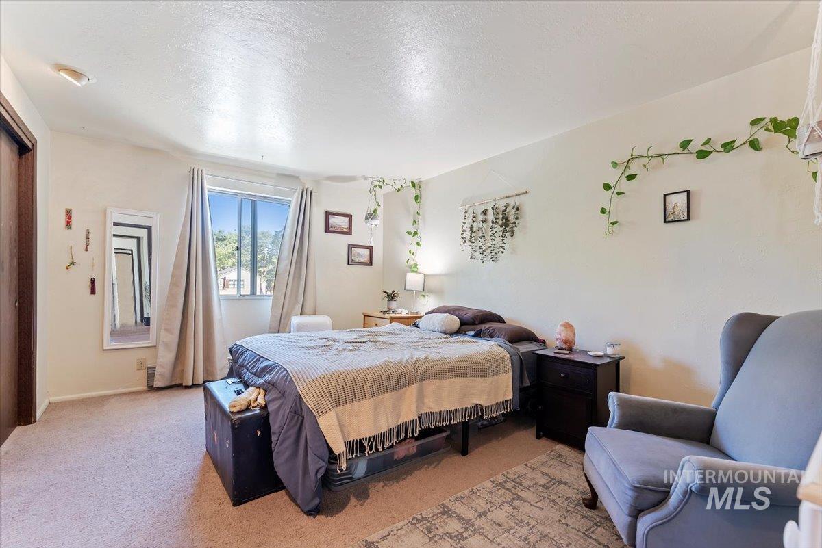 Bedroom with light carpet and a textured ceiling