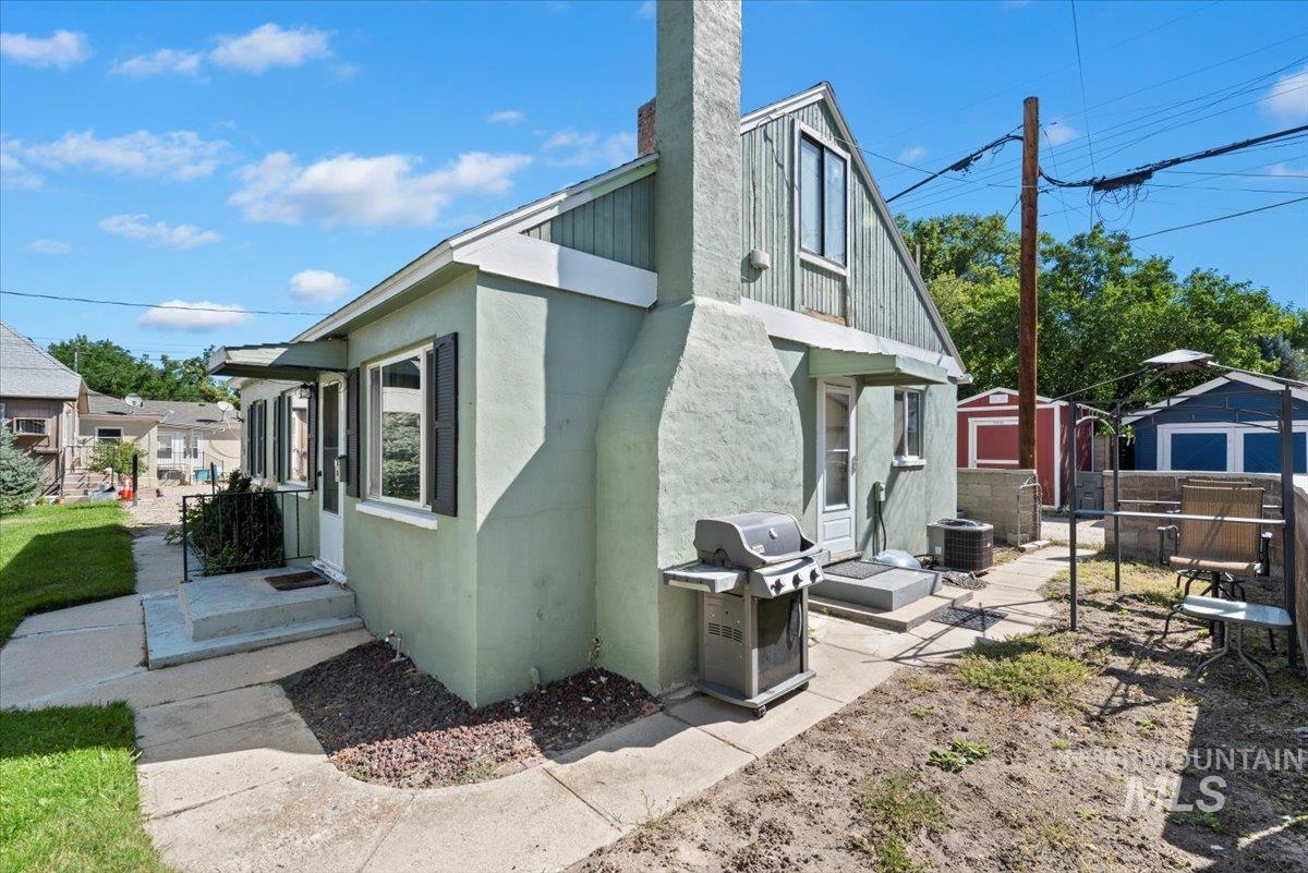 View of side of property featuring a chimney and stucco siding