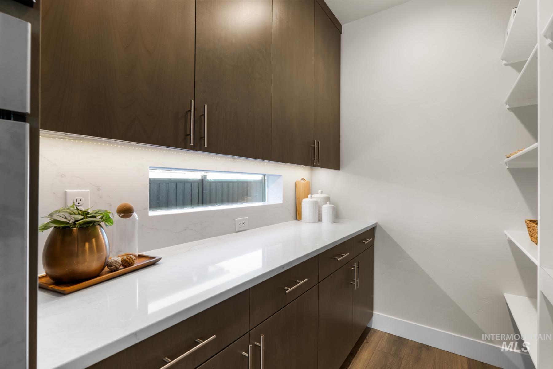 Laundry area featuring dark wood-style flooring and baseboards