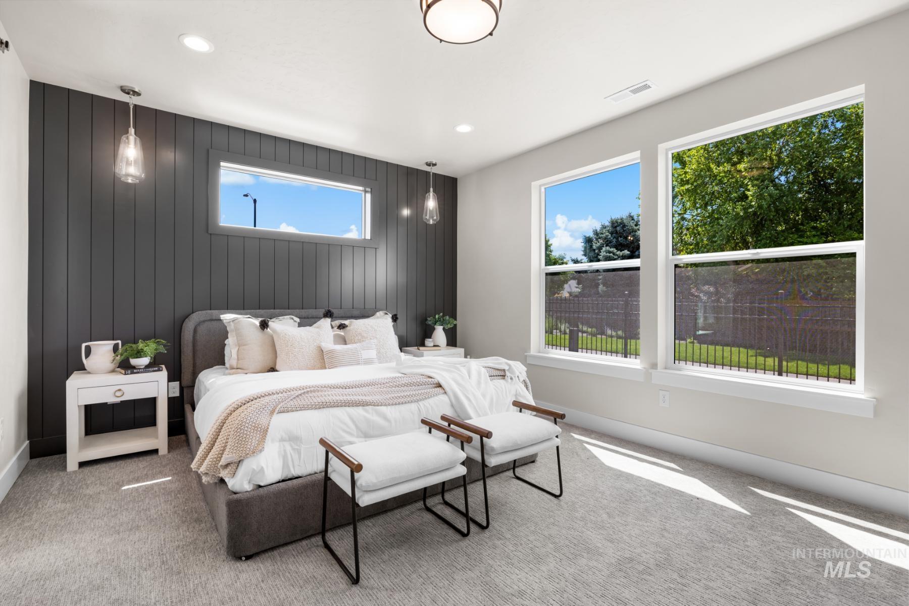 Carpeted bedroom with recessed lighting and wooden walls