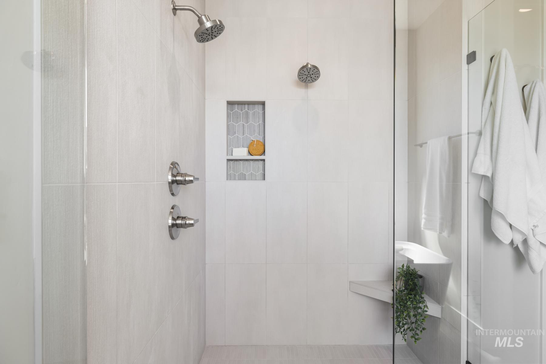 Bathroom with tiled shower and tile walls