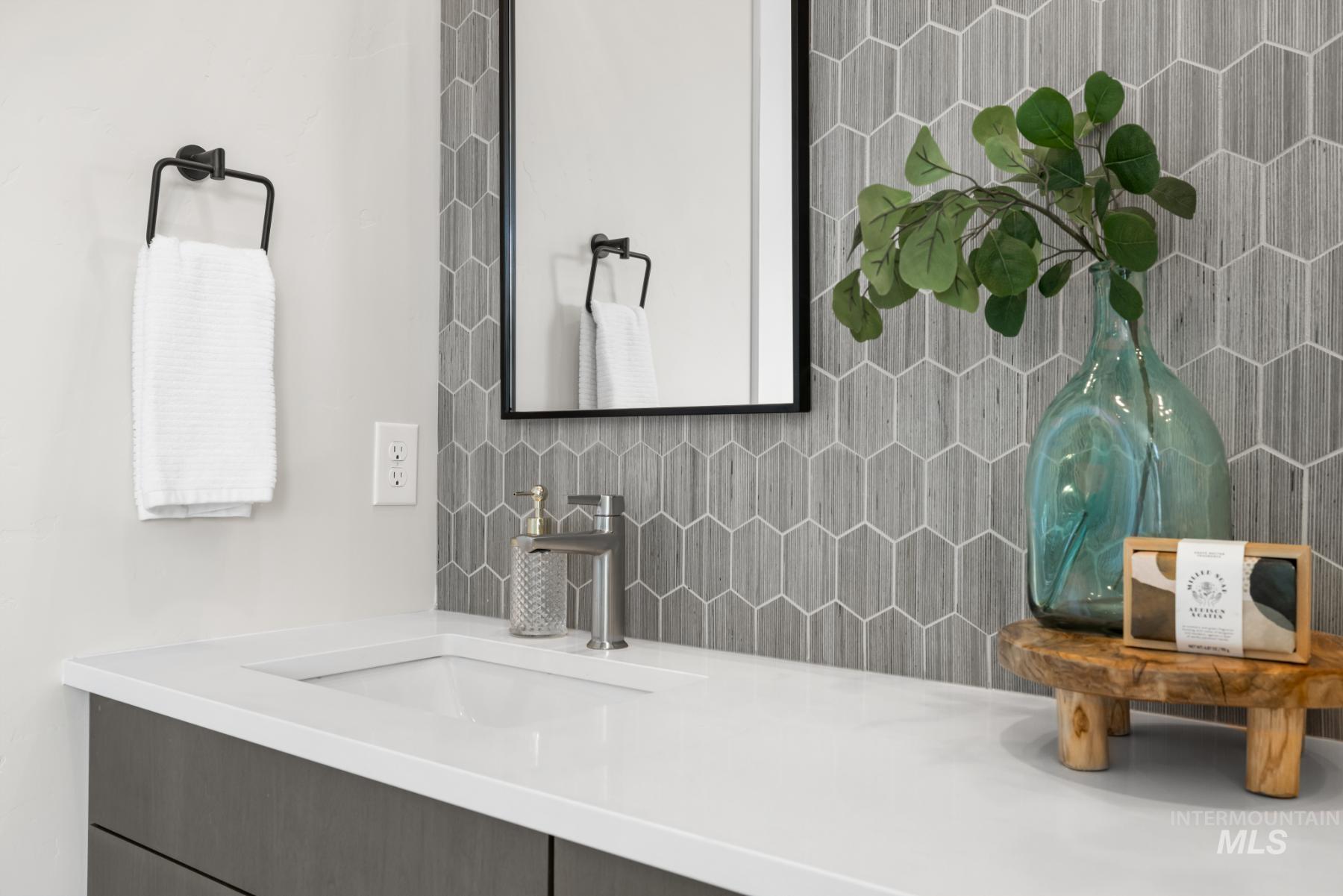 Bathroom featuring decorative backsplash and vanity