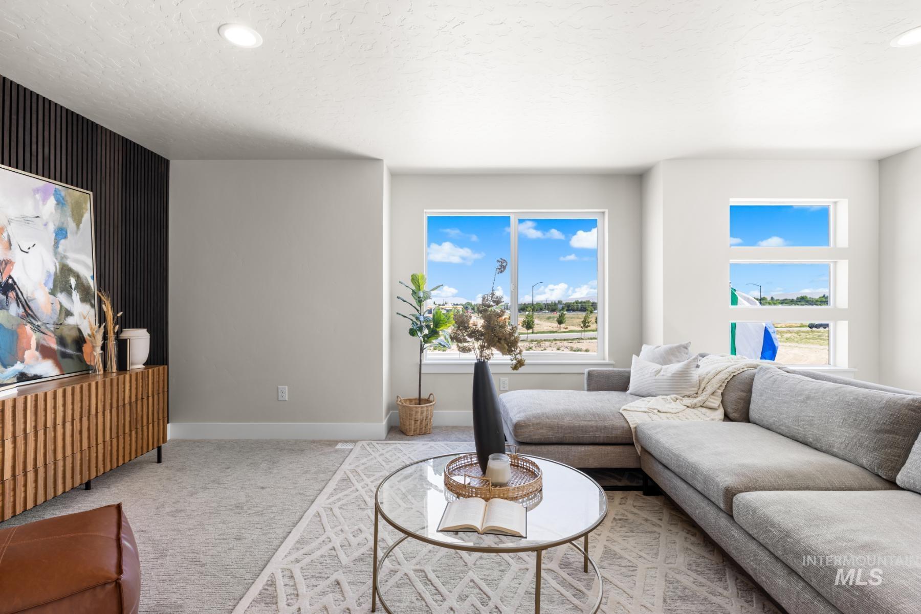 Living area featuring healthy amount of natural light, carpet floors, a textured ceiling, and recessed lighting