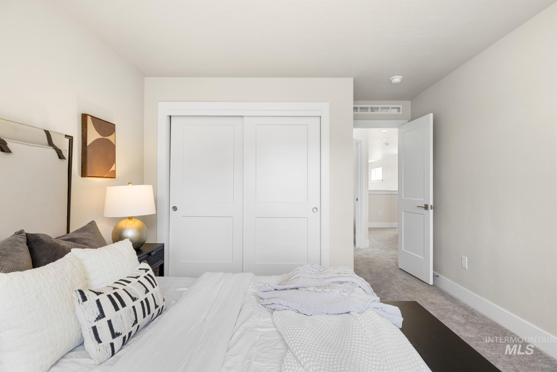 Bedroom with light carpet and a closet