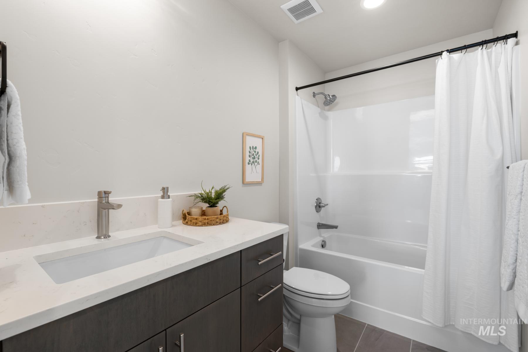 Bathroom featuring shower / bath combo with shower curtain, tile patterned flooring, vanity, and recessed lighting