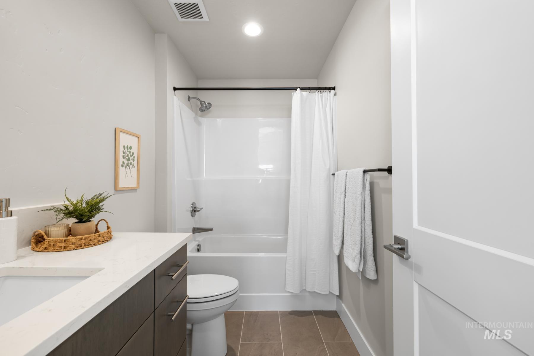 Bathroom with vanity, tile patterned floors, and shower / tub combo