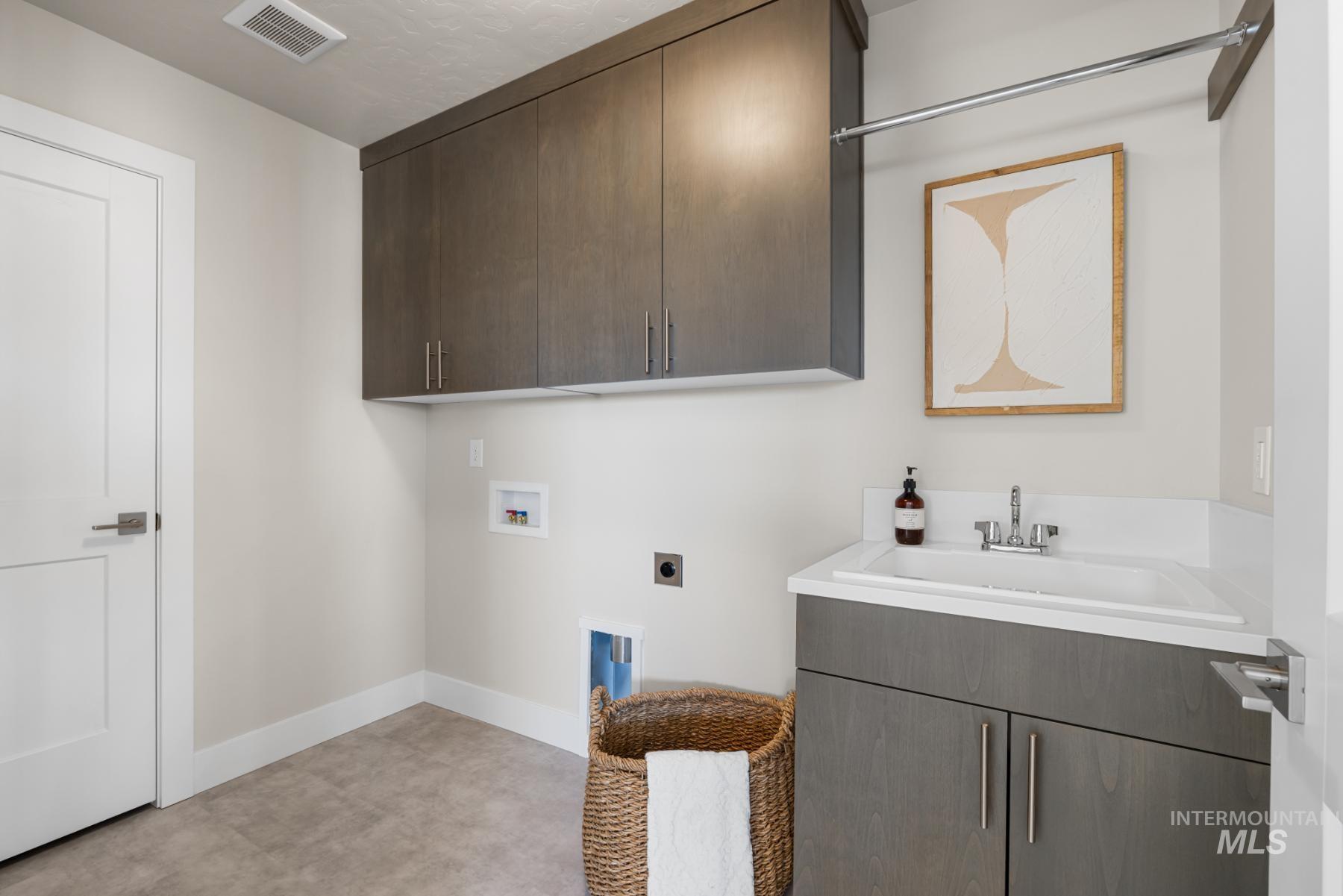 Laundry area with cabinet space, electric dryer hookup, and hookup for a washing machine