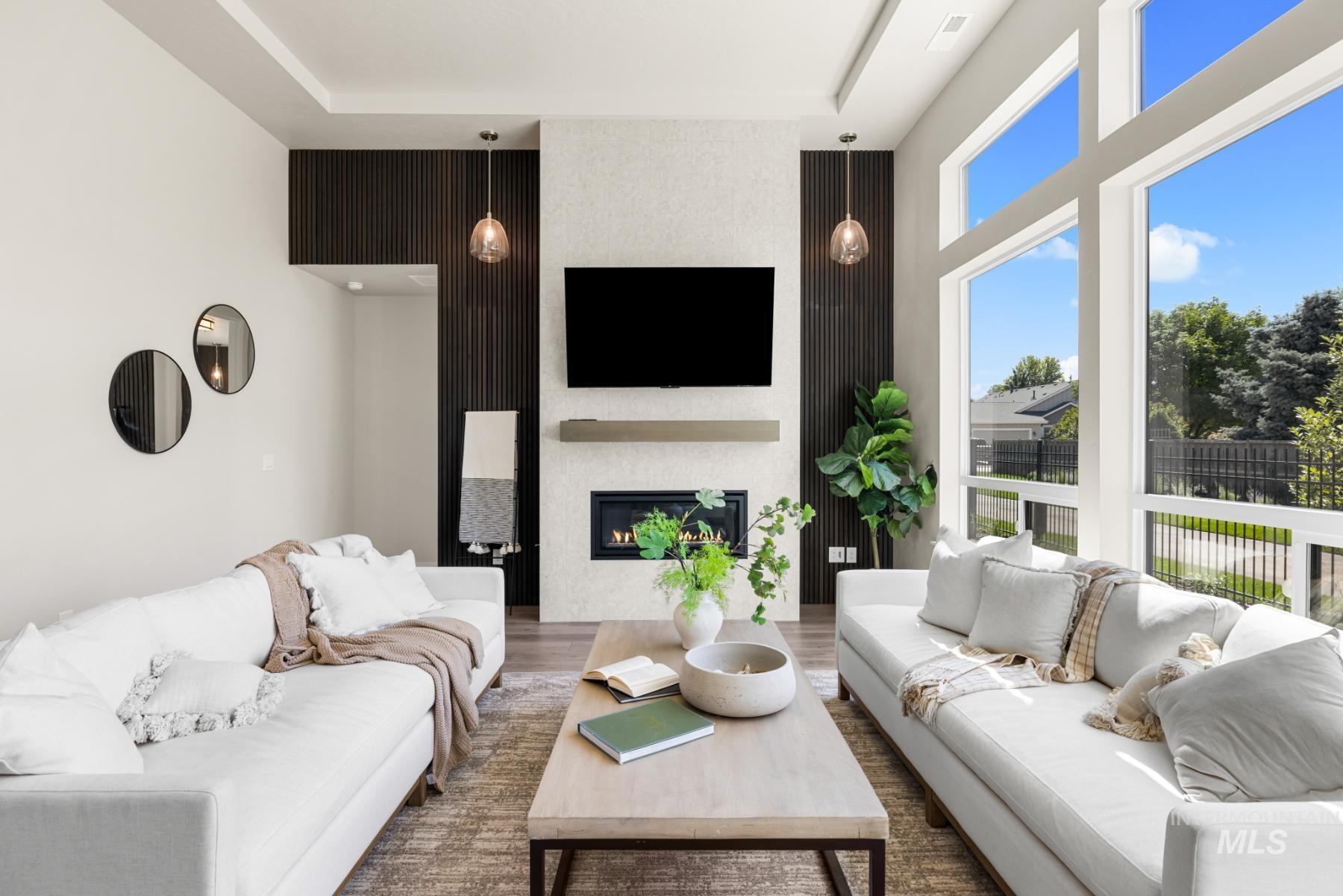 Living room featuring an accent wall, wood finished floors, and a fireplace