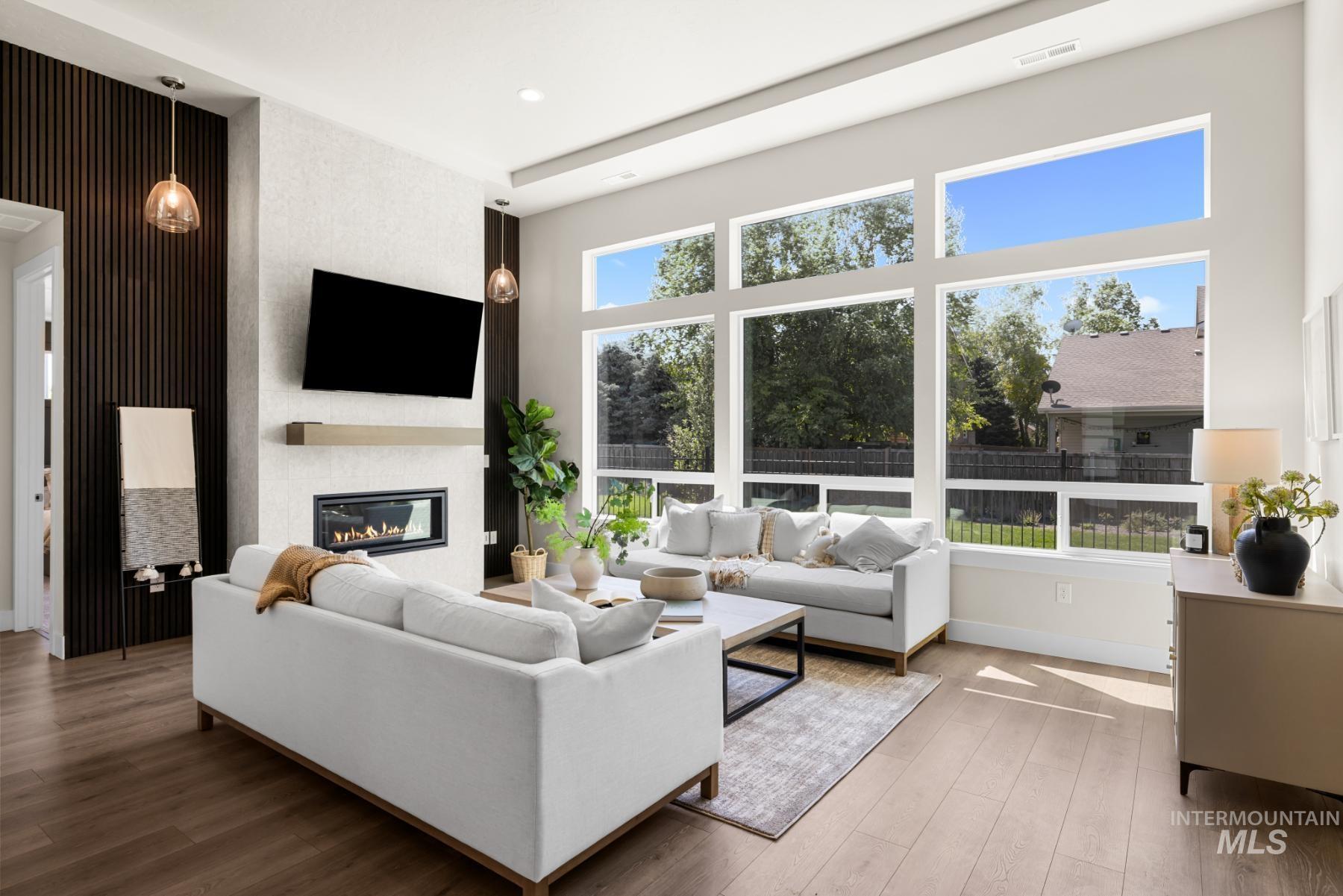 Living area featuring a large fireplace, wood finished floors, recessed lighting, and an accent wall