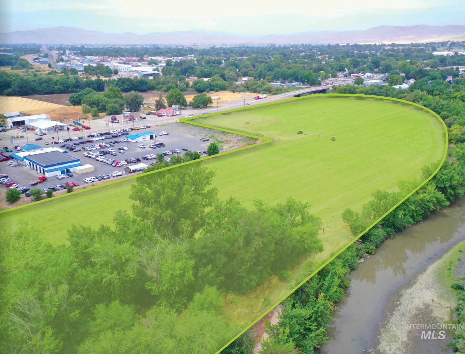 Aerial view of property and surrounding area with a mountain backdrop and property boundaries highlighted