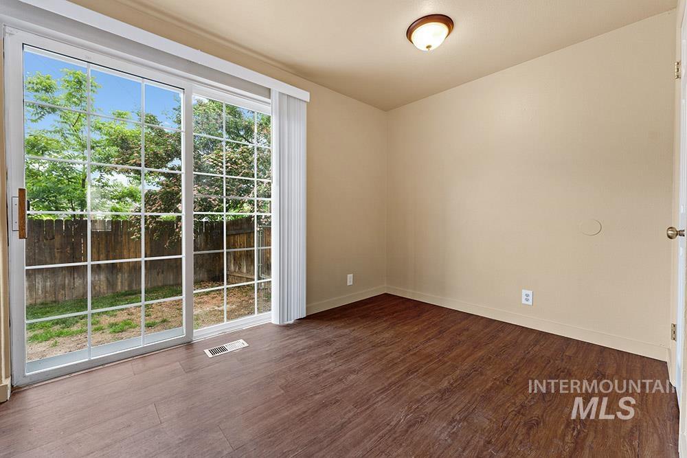 Spare room featuring dark wood-style flooring