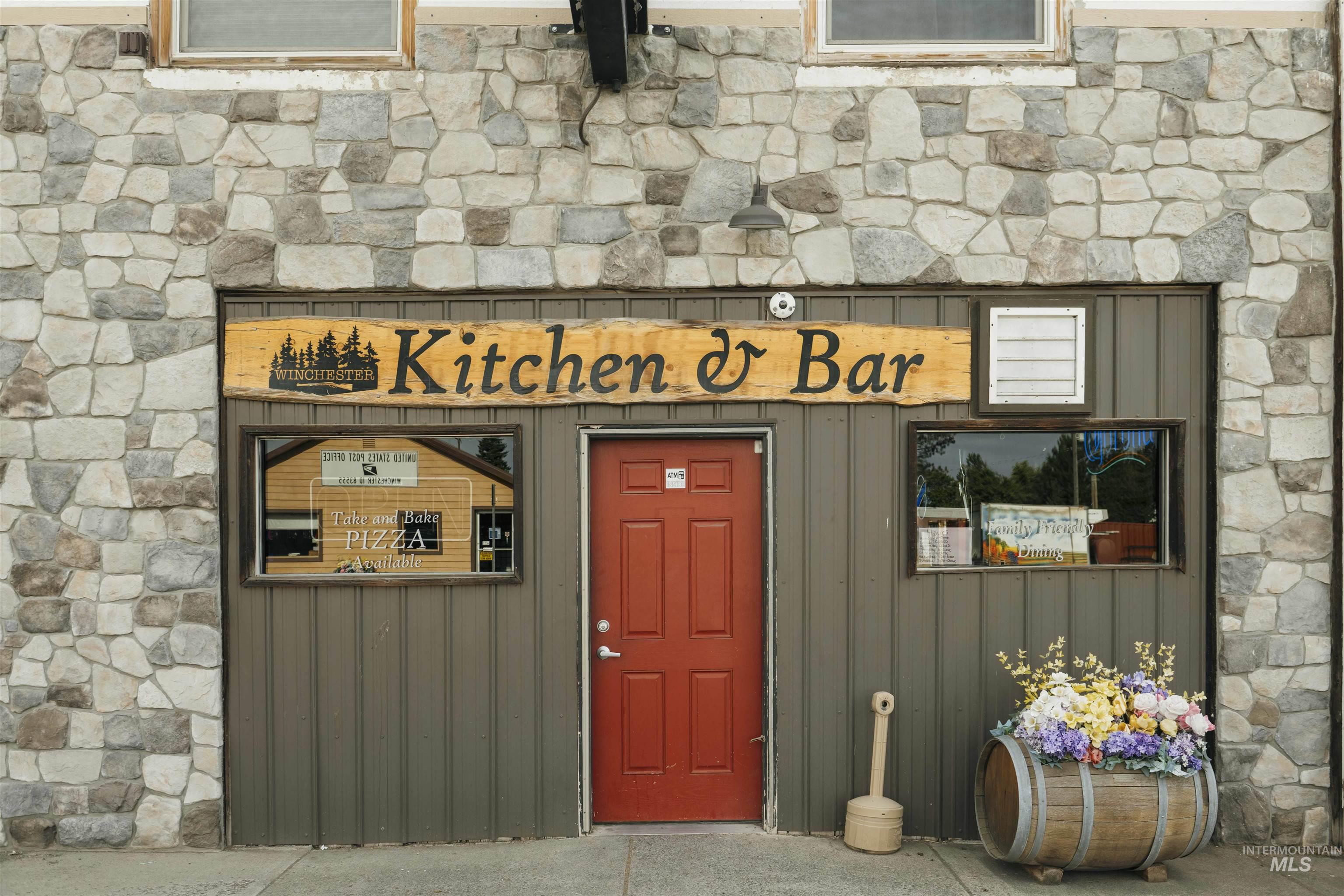 View of exterior entry featuring stone siding and board and batten siding