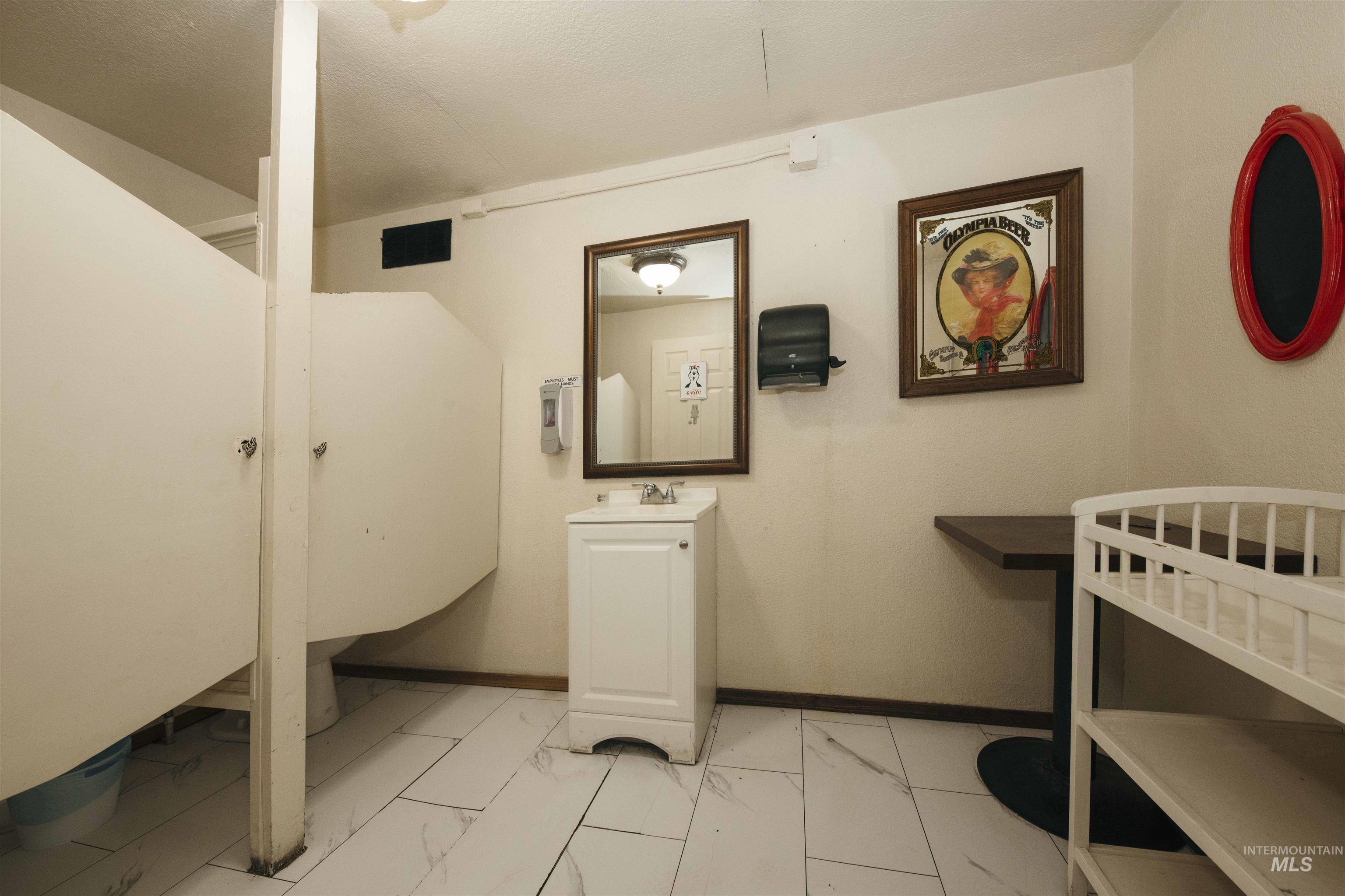 Laundry area featuring light marble finish floors and baseboards