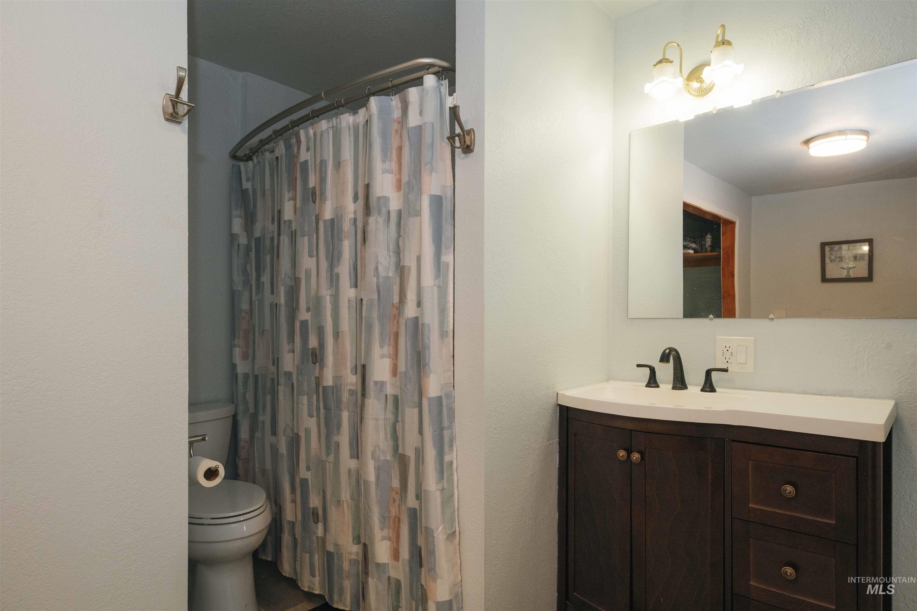 Bathroom featuring vanity, curtained shower, and a textured wall