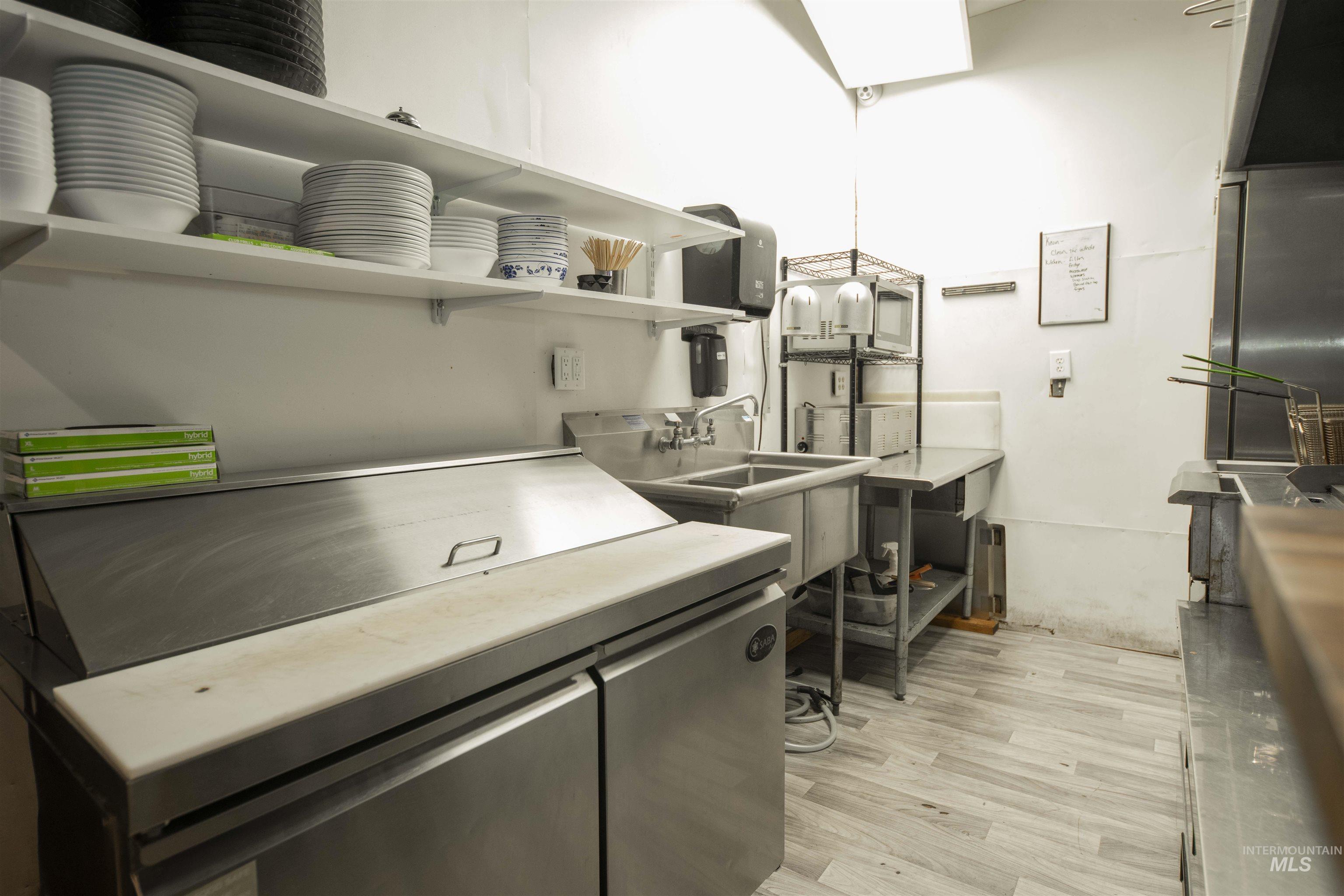 Kitchen with open shelves, light wood-style flooring, and light countertops
