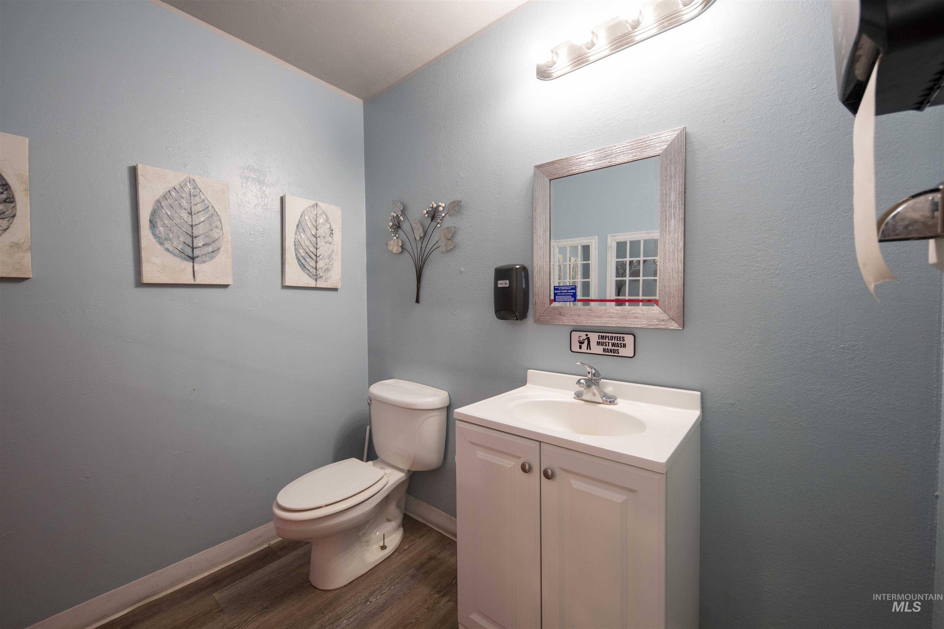 Half bathroom with wood finished floors and vanity