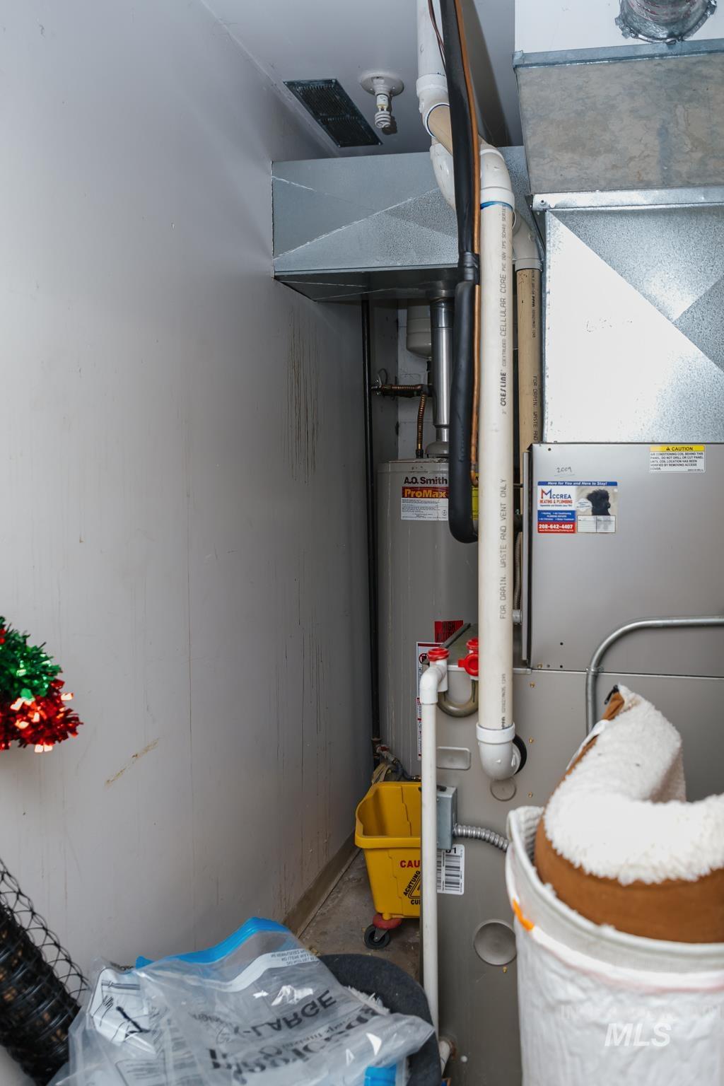 Utility room with gas water heater and heating unit