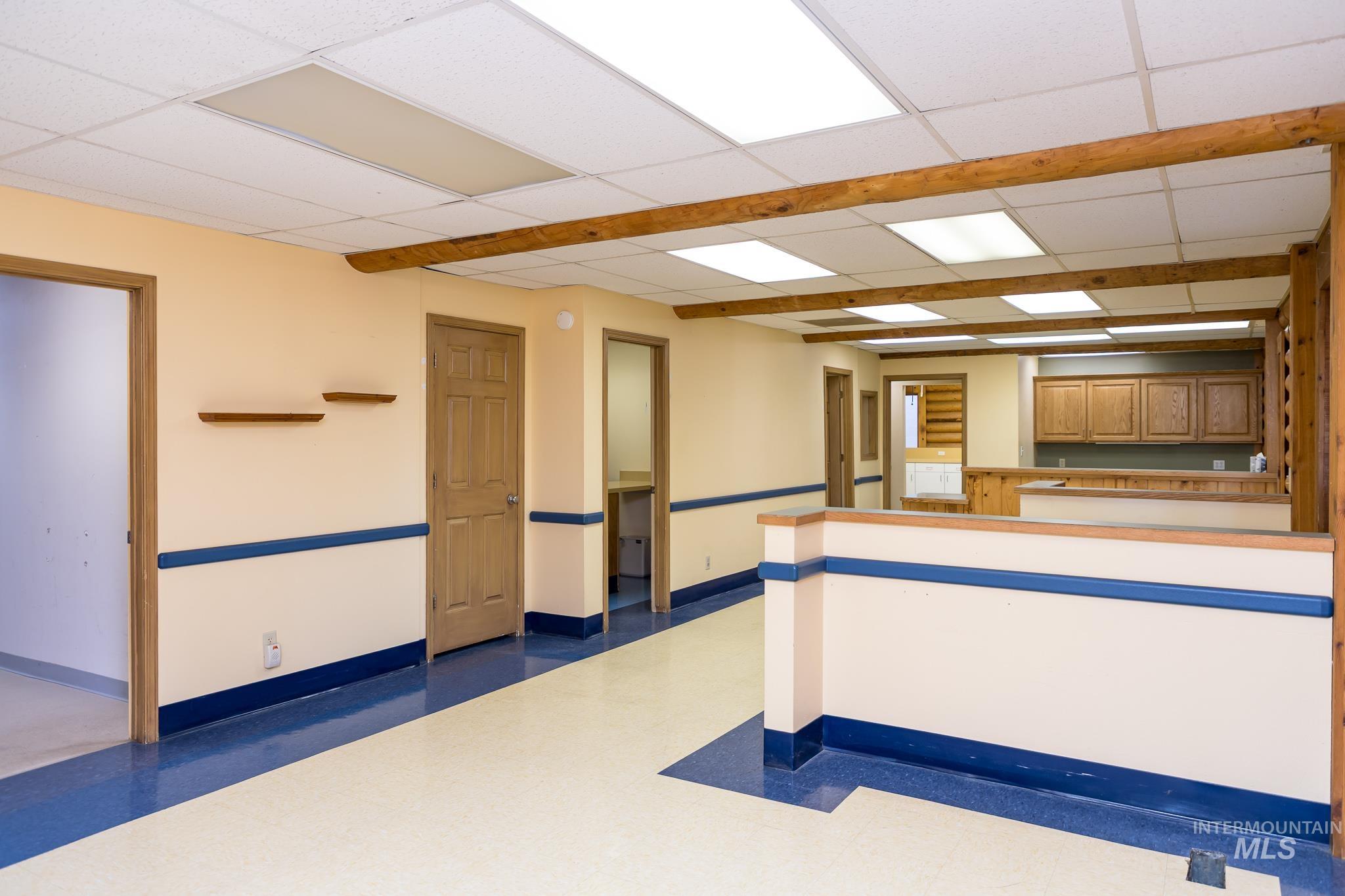 Unfurnished room with a drop ceiling and baseboards