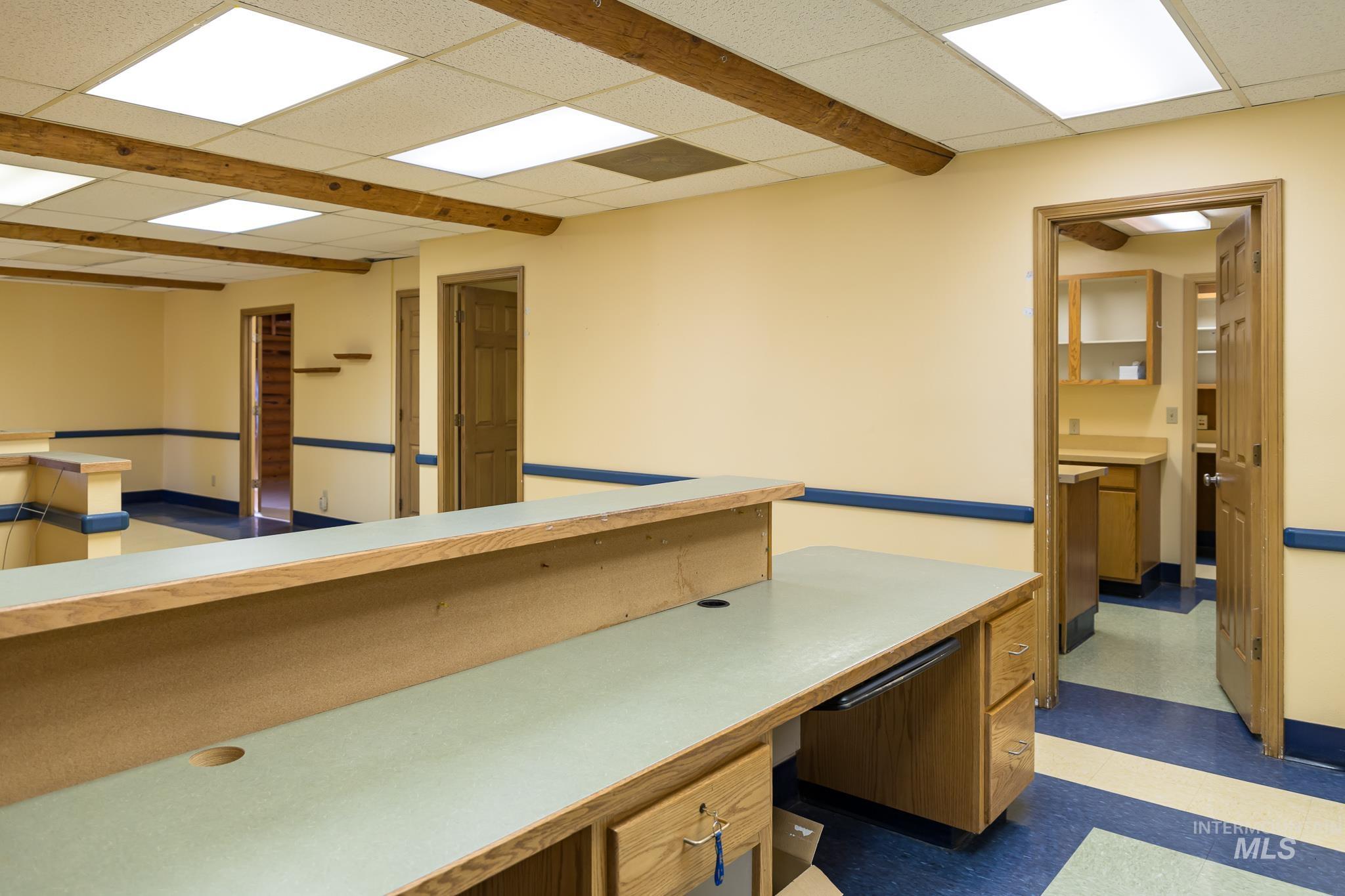 Office area with dark floors and a paneled ceiling