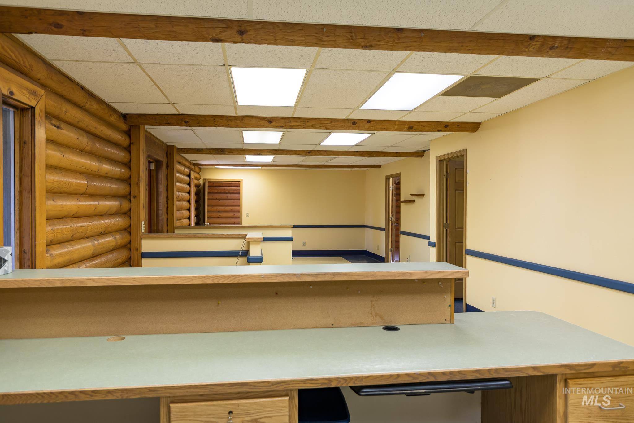 Kitchen with light countertops, built in study area, and a paneled ceiling