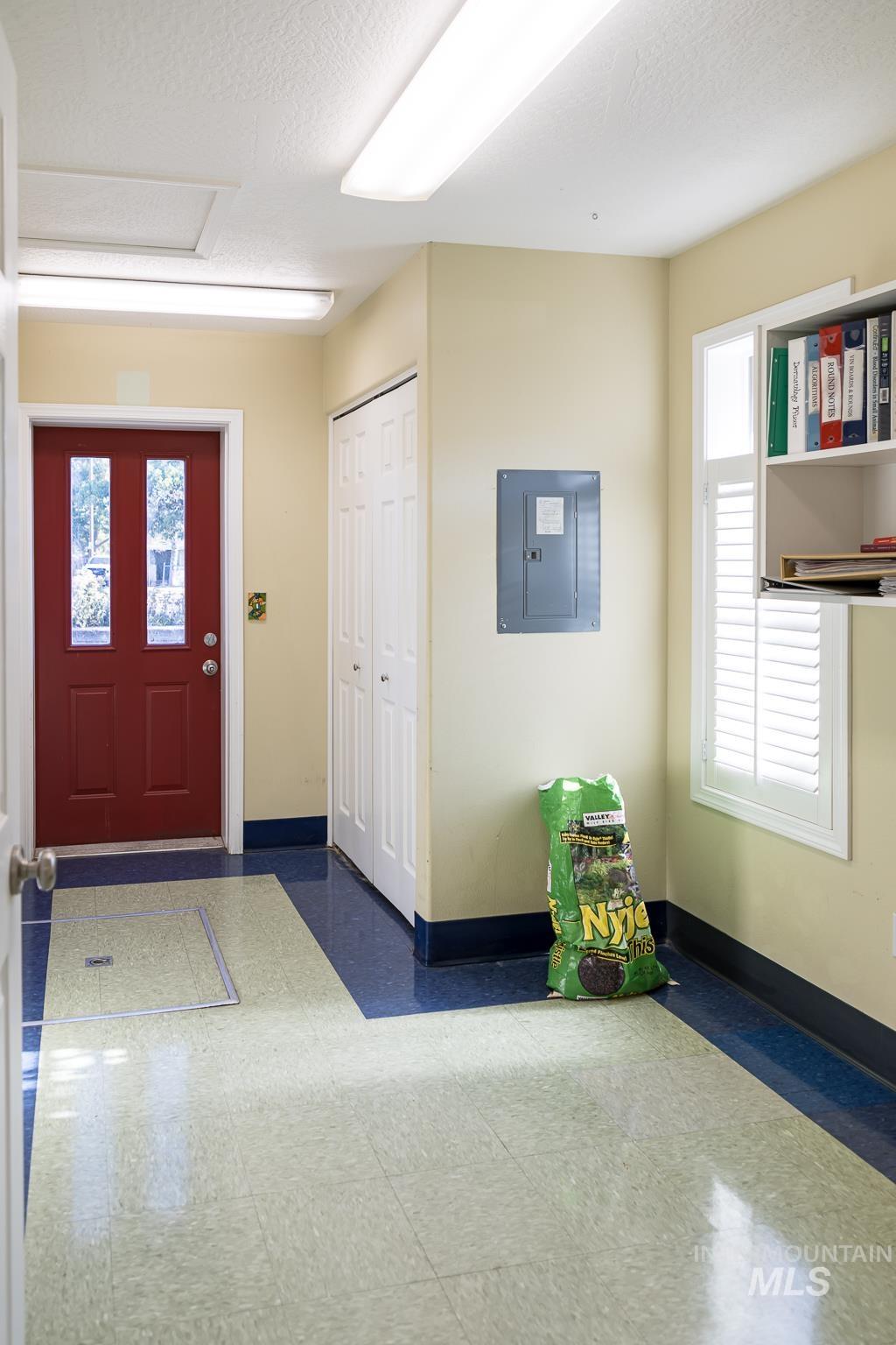 Foyer featuring healthy amount of natural light, electric panel, and a textured ceiling