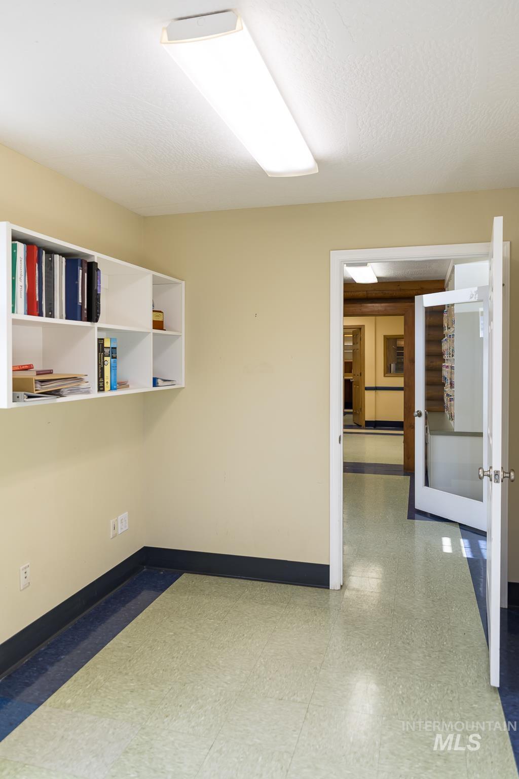 Unfurnished room with dark floors and a textured ceiling