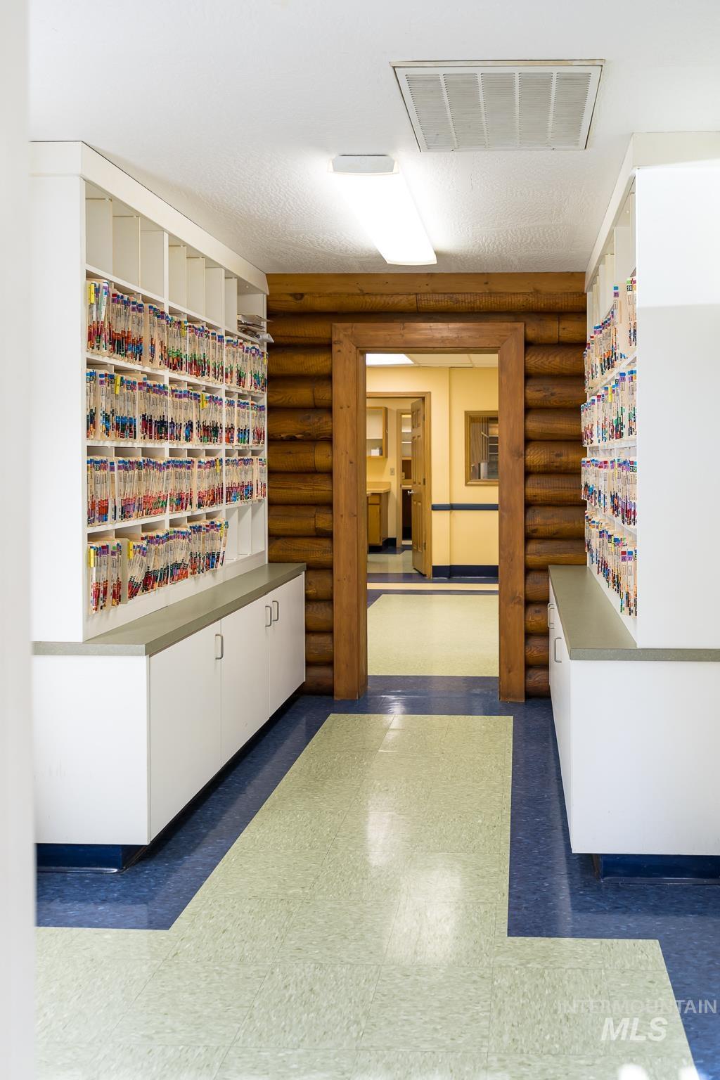 Corridor with dark floors, rustic walls, and a textured ceiling