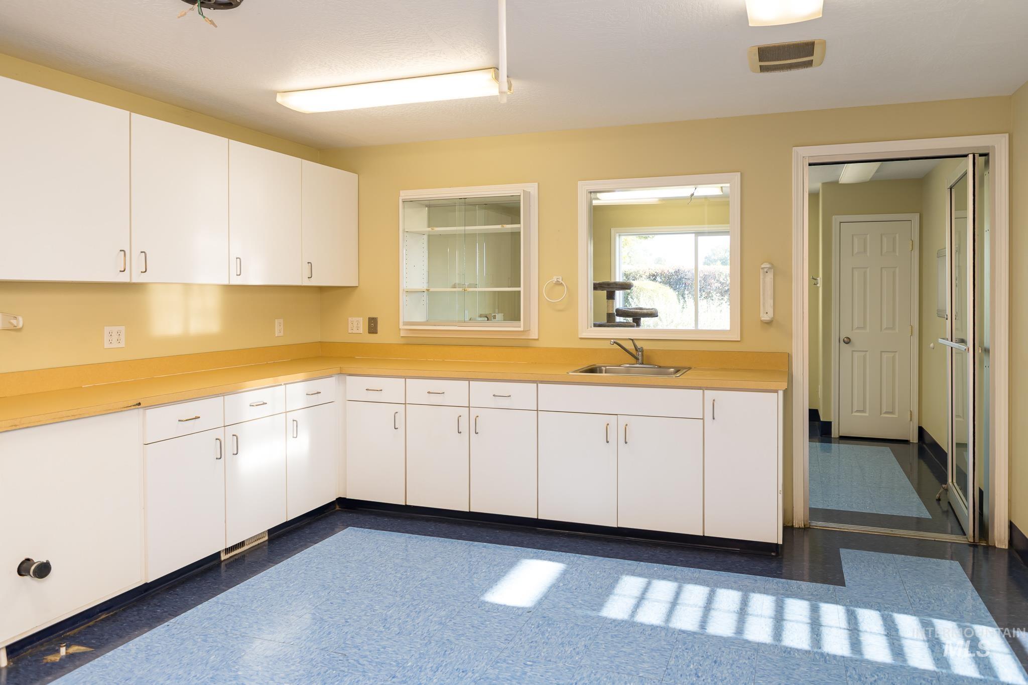 Kitchen featuring light countertops and white cabinetry