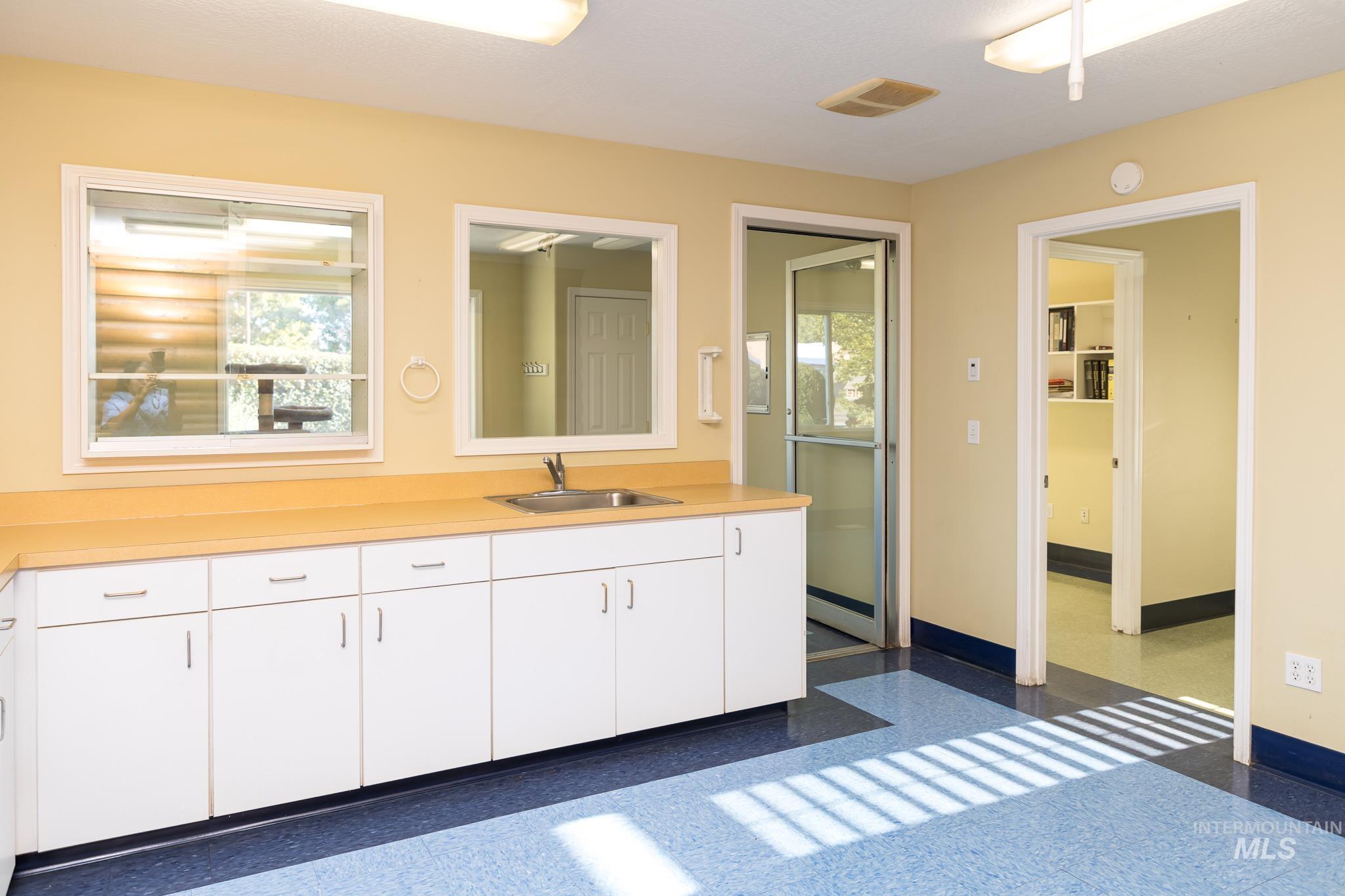 Bathroom featuring vanity, healthy amount of natural light, and light speckled floor