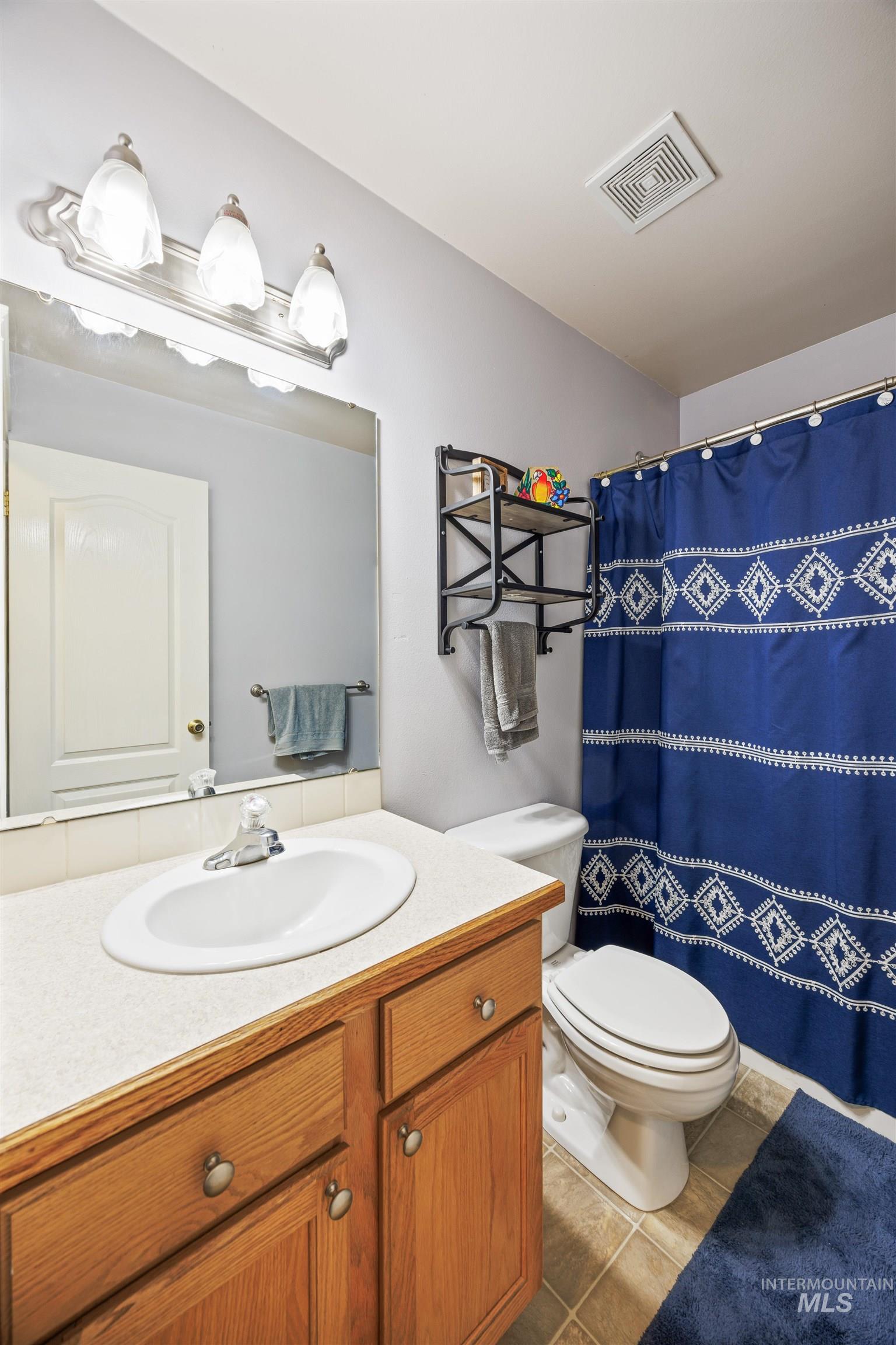 Full bath with vanity, tile patterned flooring, and a shower with shower curtain