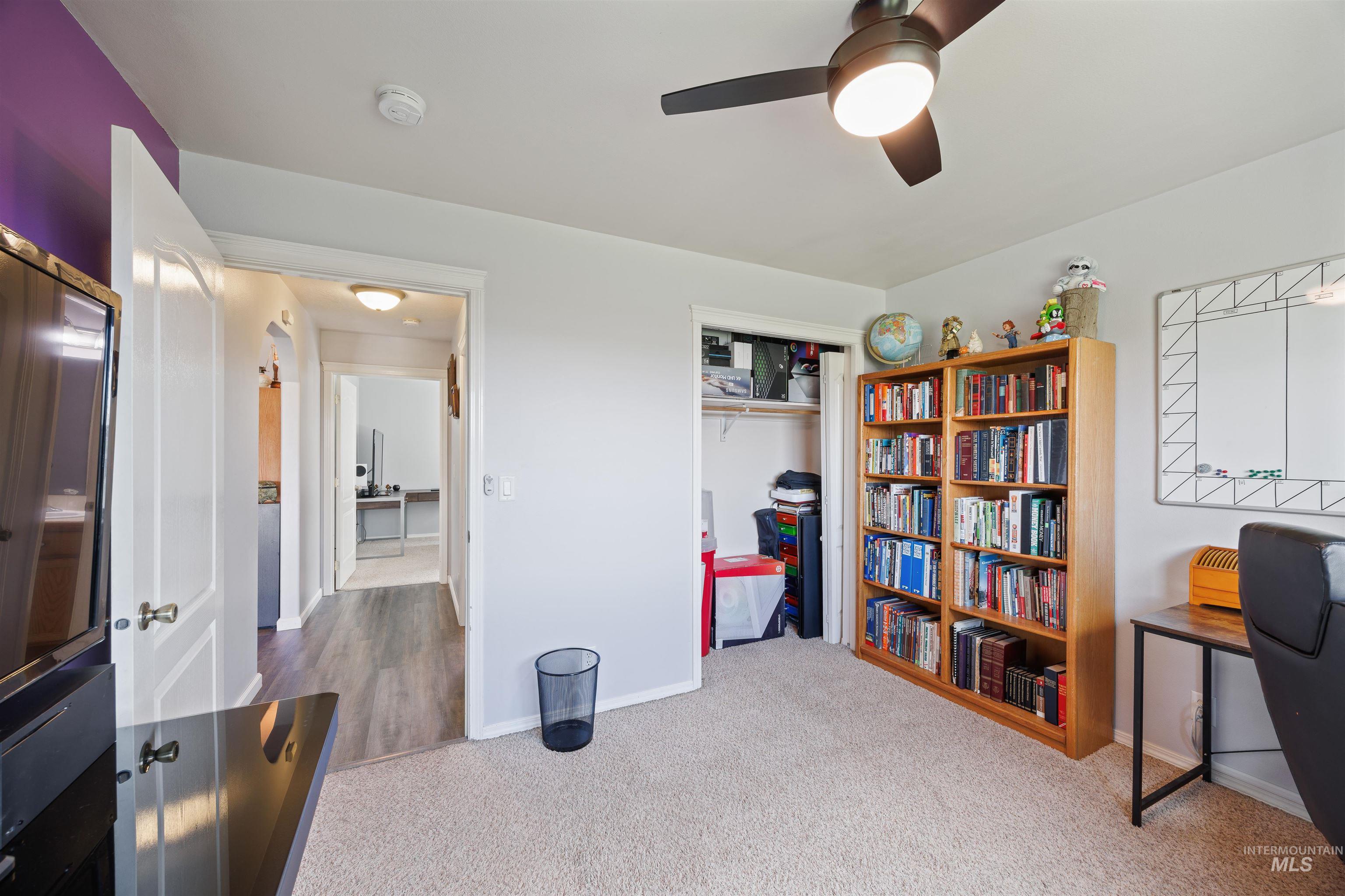Carpeted office space with baseboards and ceiling fan