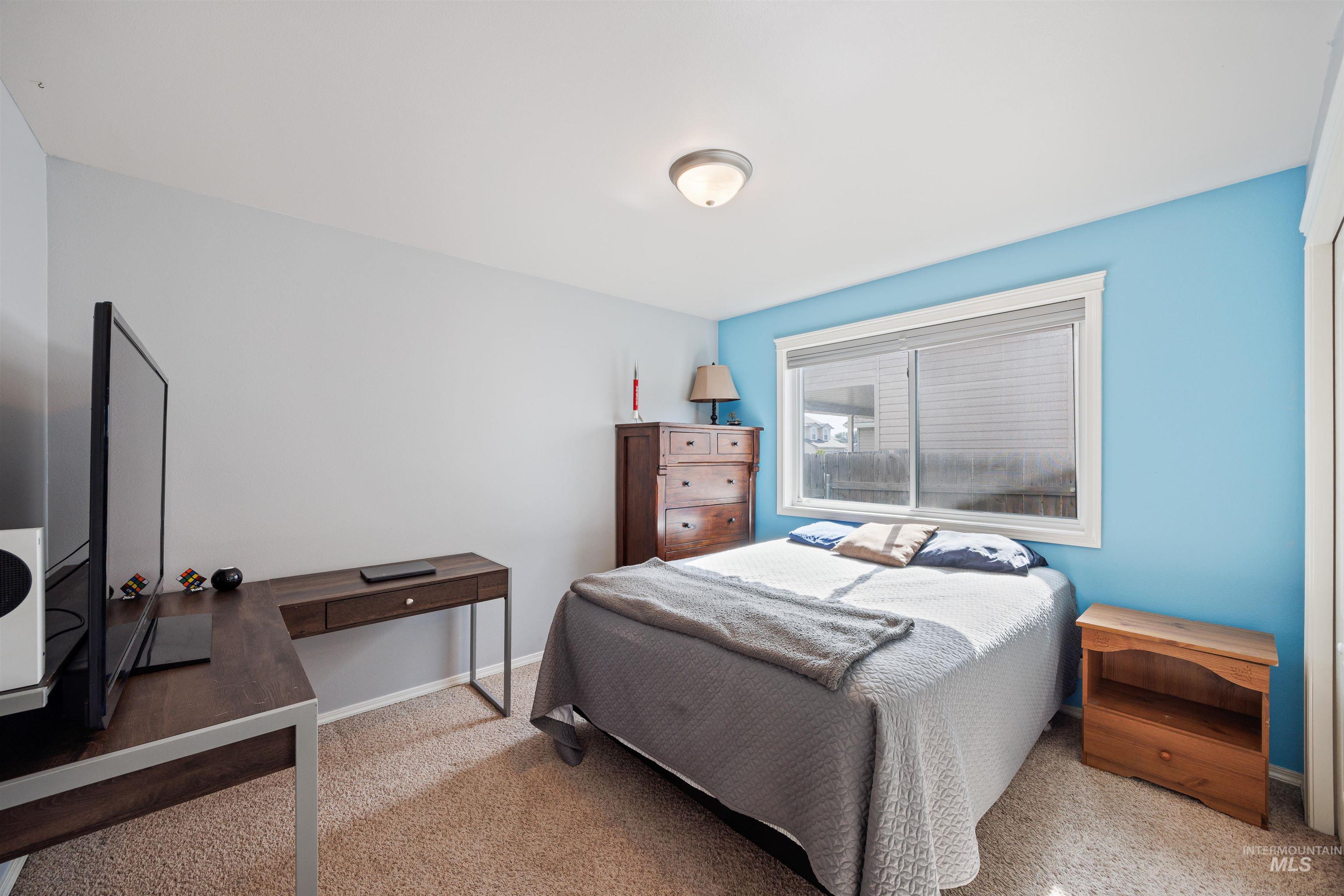 Bedroom featuring carpet and baseboards