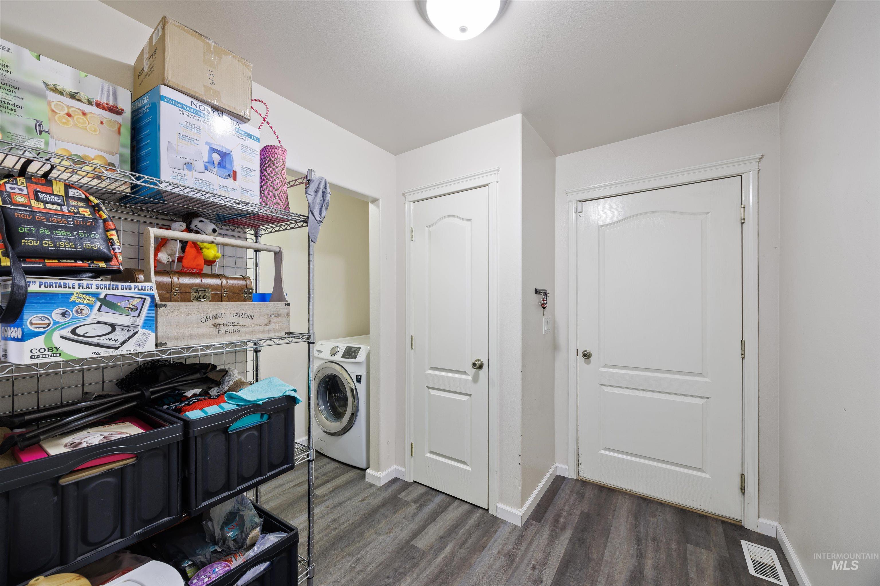 Laundry area featuring dark wood-type flooring and washer / dryer