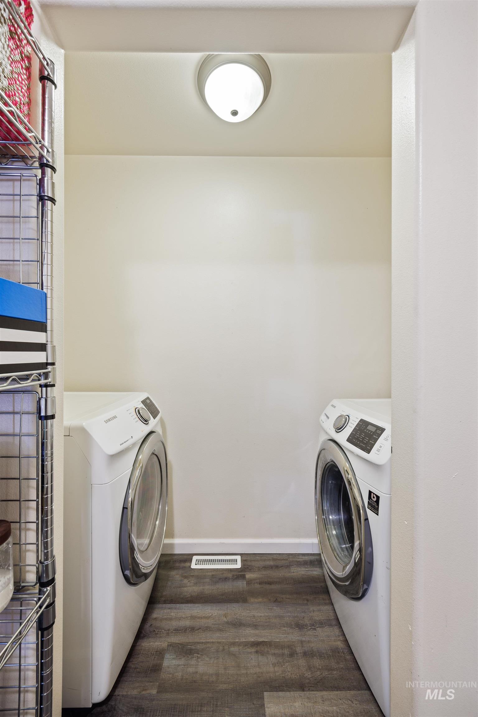 Laundry area featuring dark wood-type flooring and separate washer and dryer
