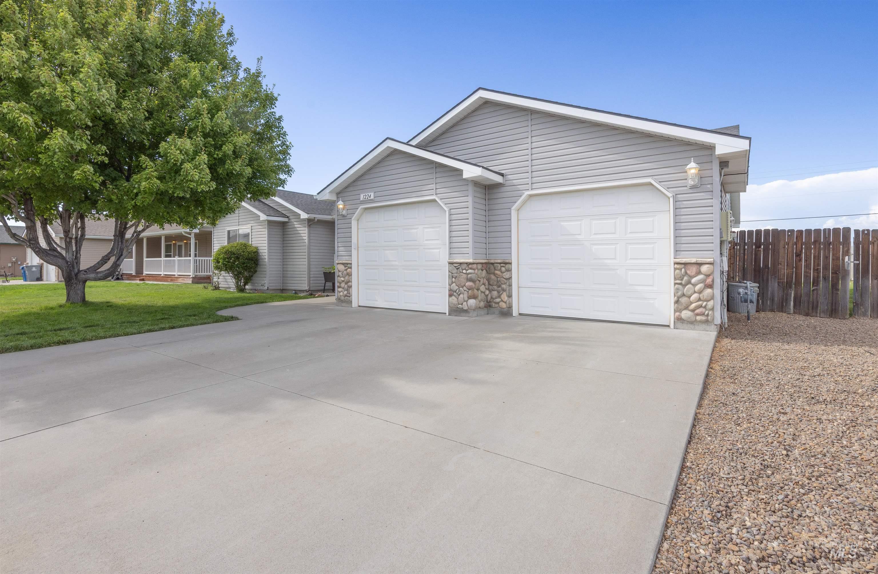 Ranch-style home with stone siding, driveway, and a garage