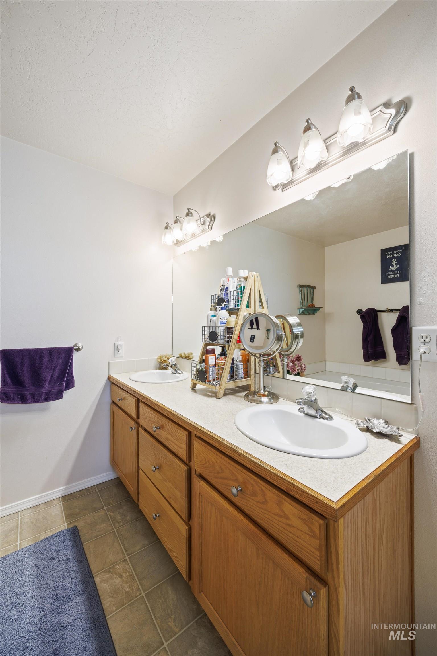 Full bath with double vanity and tile patterned flooring