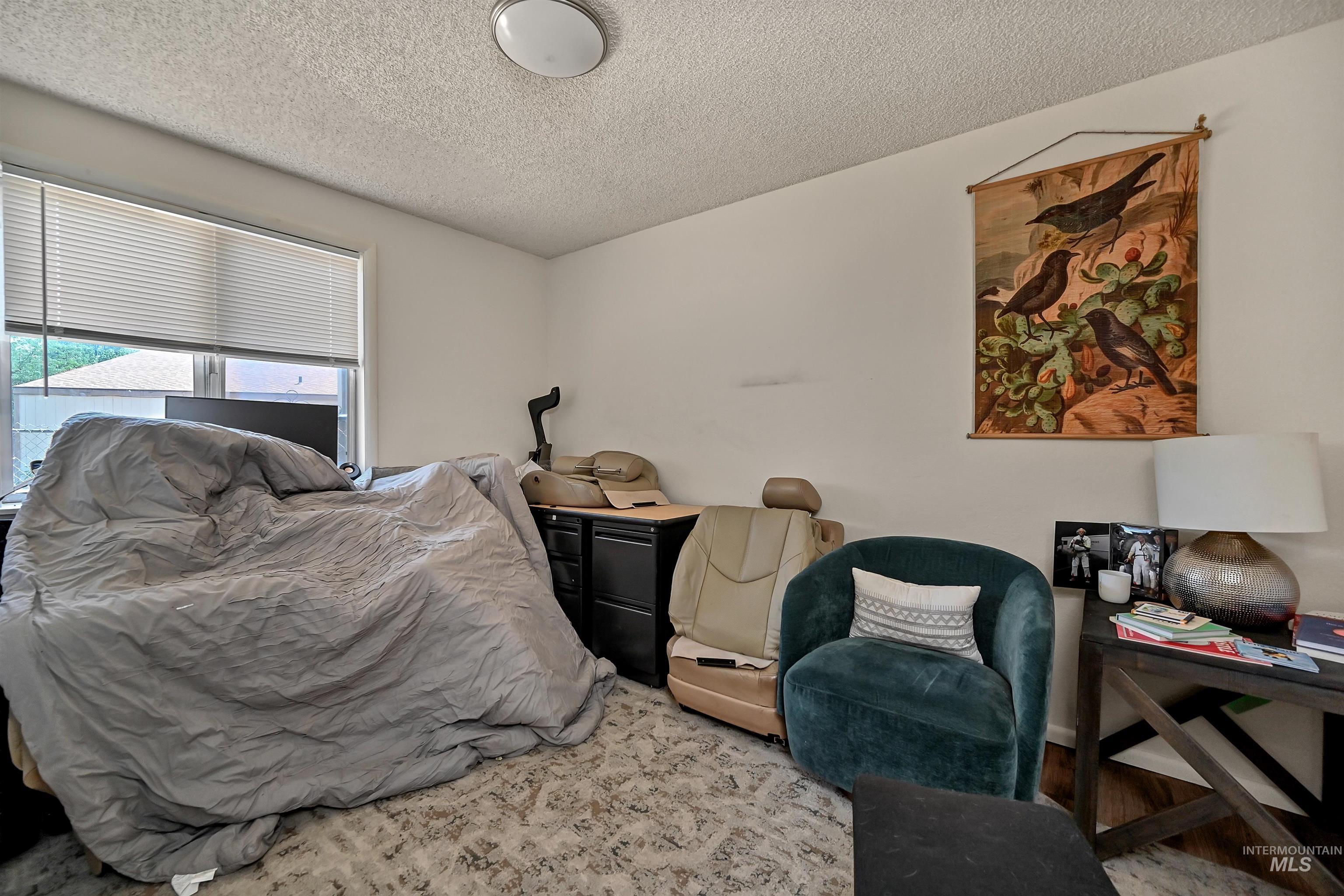 Bedroom featuring a textured ceiling and wood finished floors