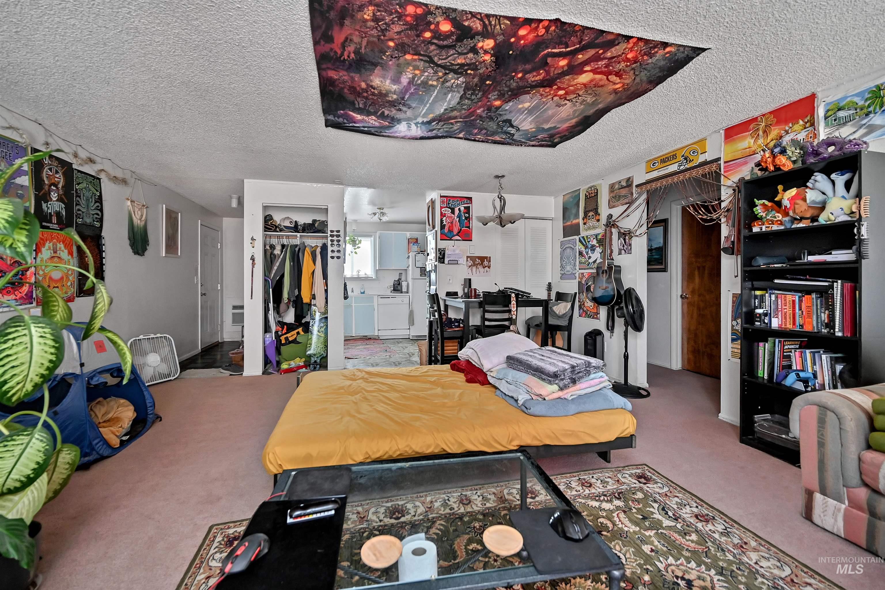 Carpeted home office with a textured ceiling