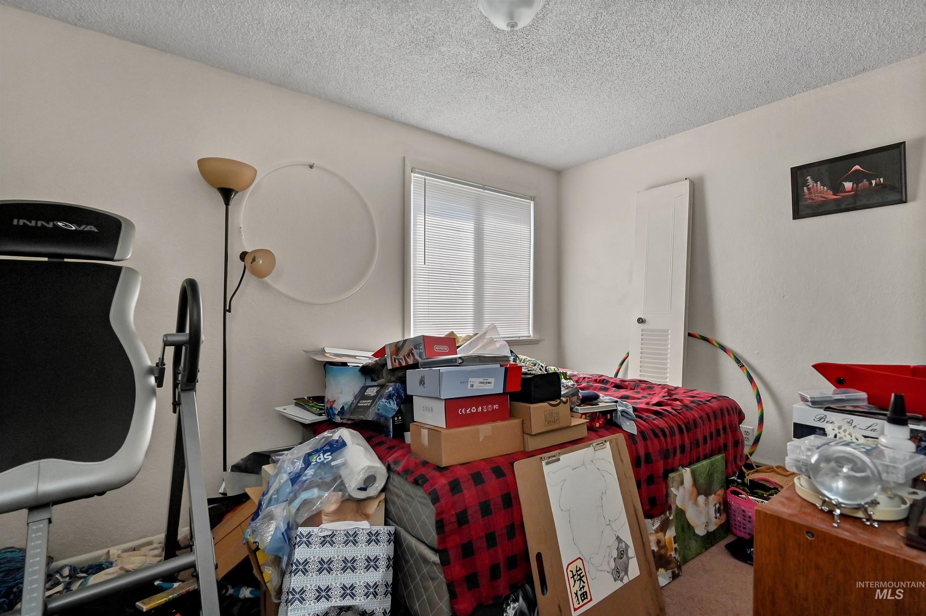 Bedroom with a textured ceiling and carpet floors