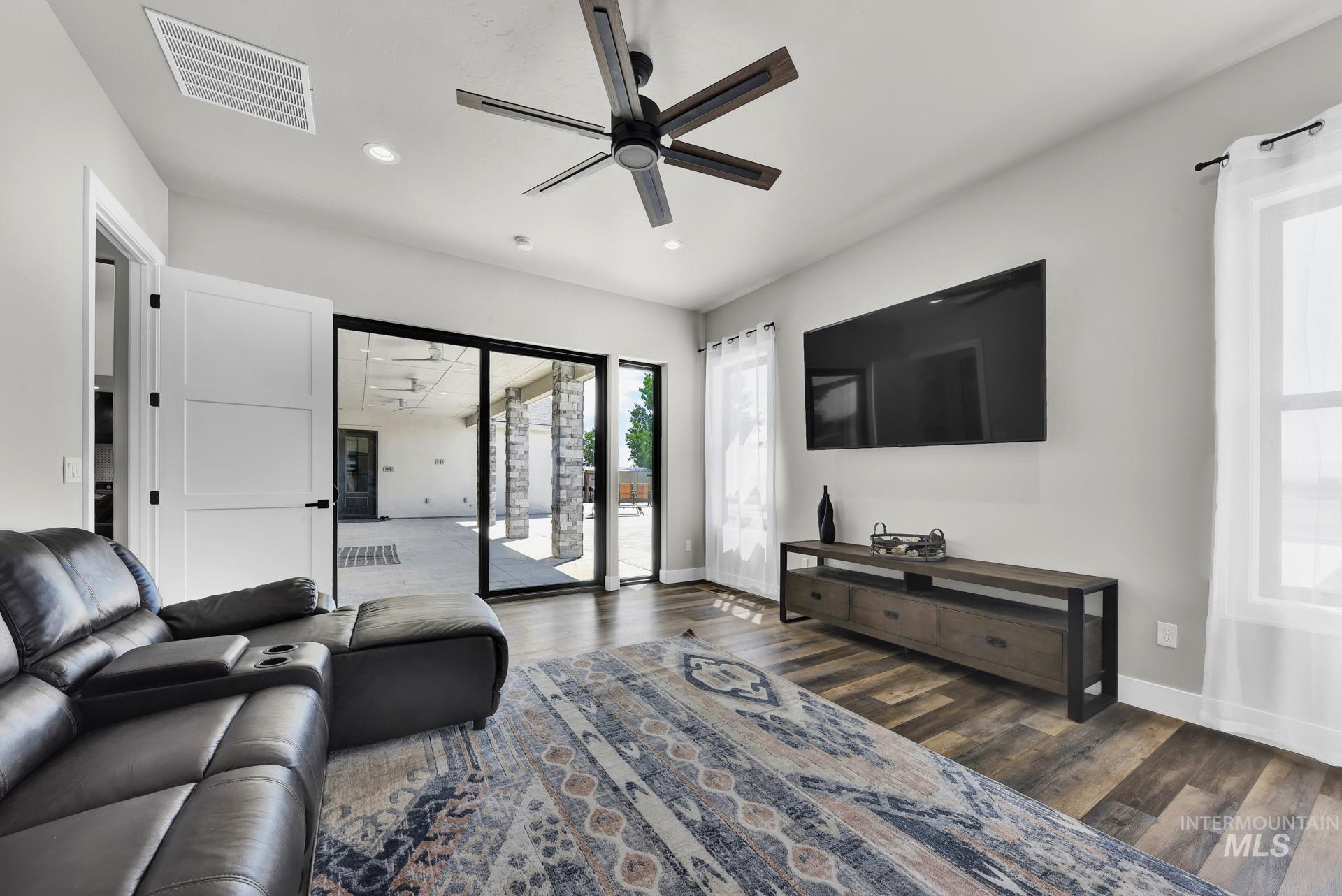 Living room featuring wood finished floors, ceiling fan, and recessed lighting