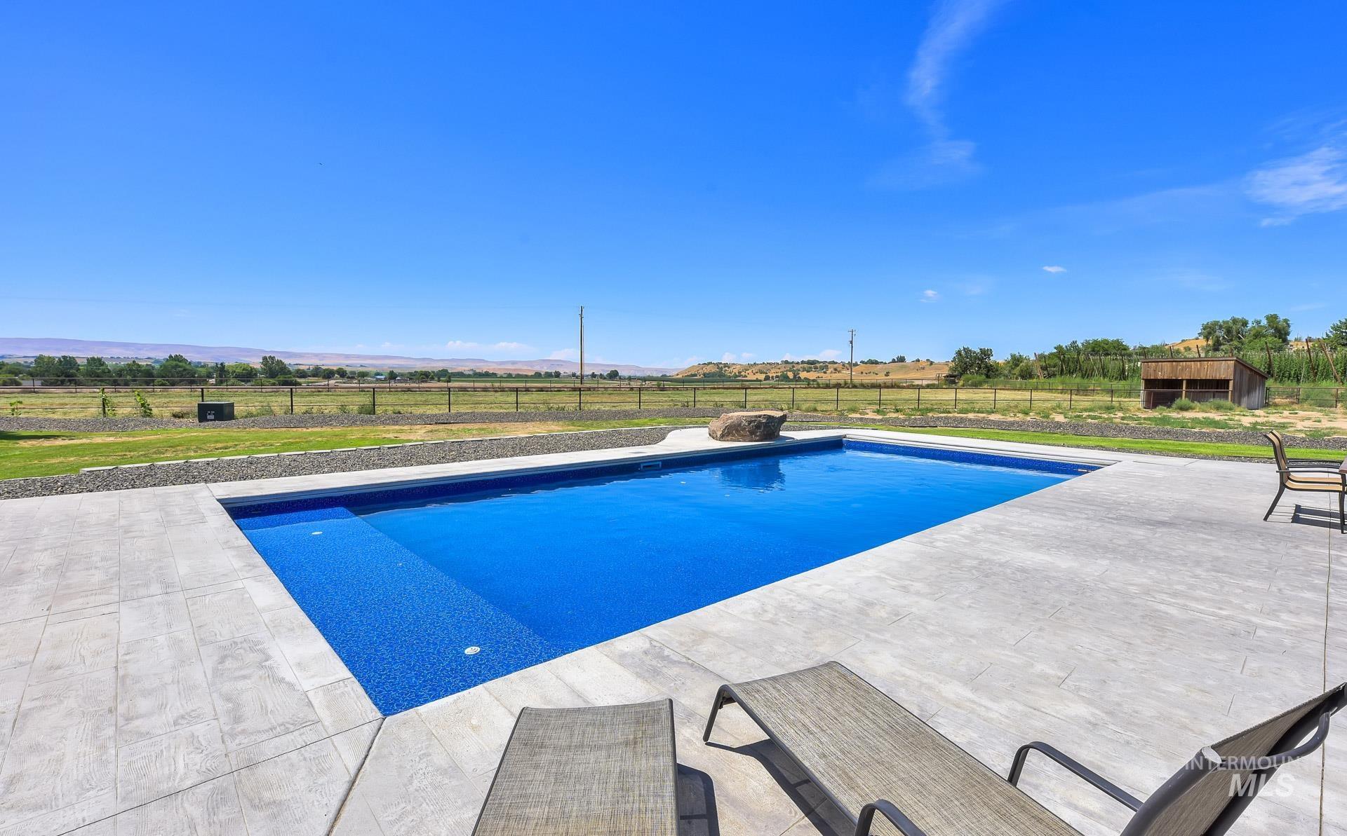 View of pool featuring a patio, a rural view, and a mountain view
