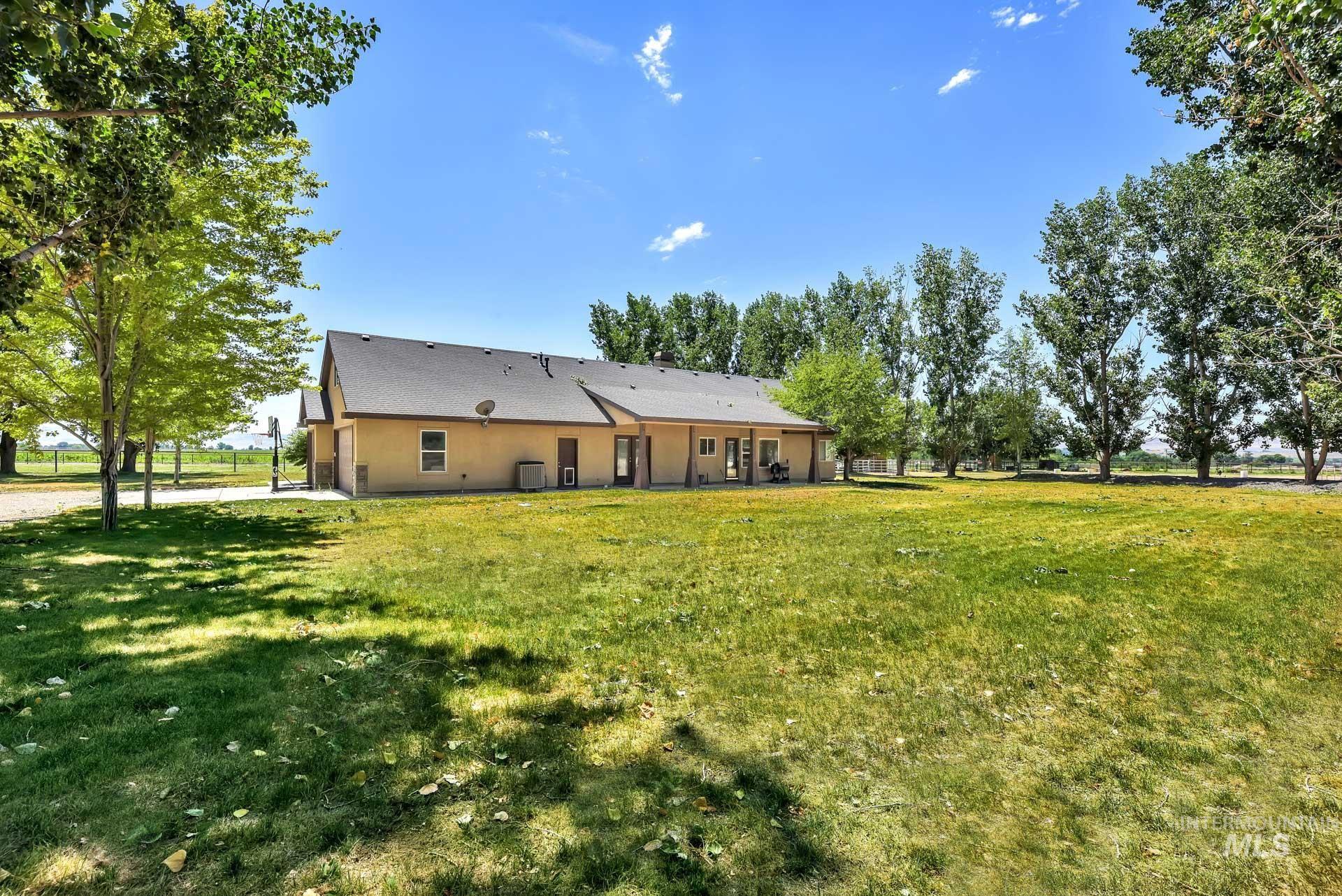 Rear view of house featuring a lawn and stucco siding
