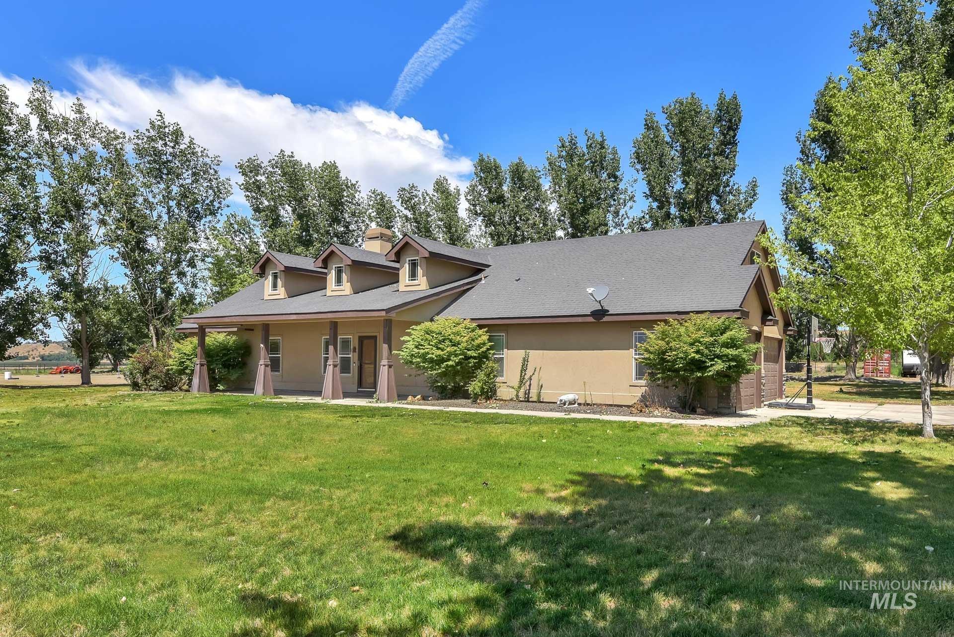 View of front of property featuring a front yard, stucco siding, a chimney, and a shingled roof