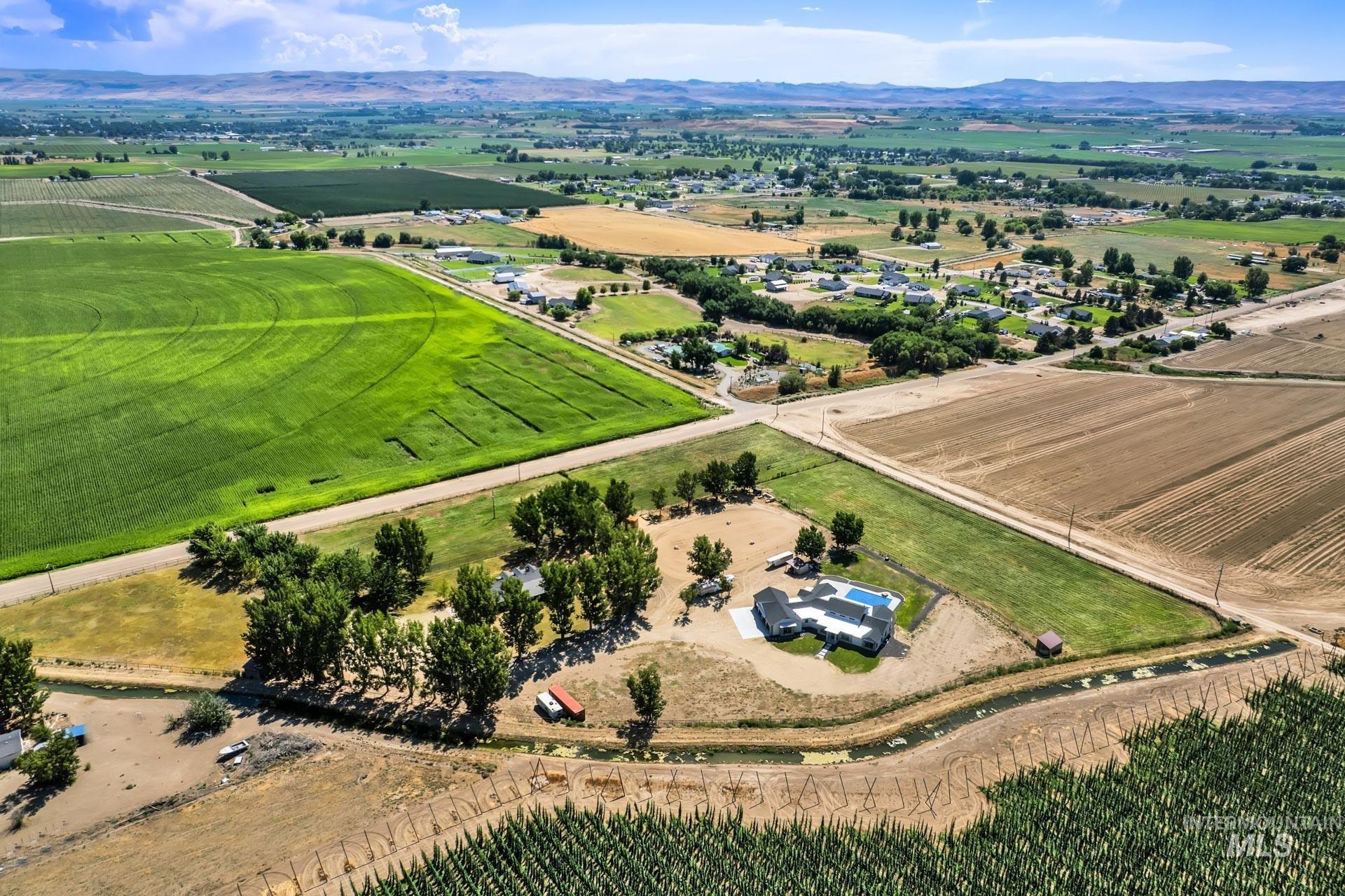 Aerial view of sparsely populated area with abundant farmland and a mountainous background