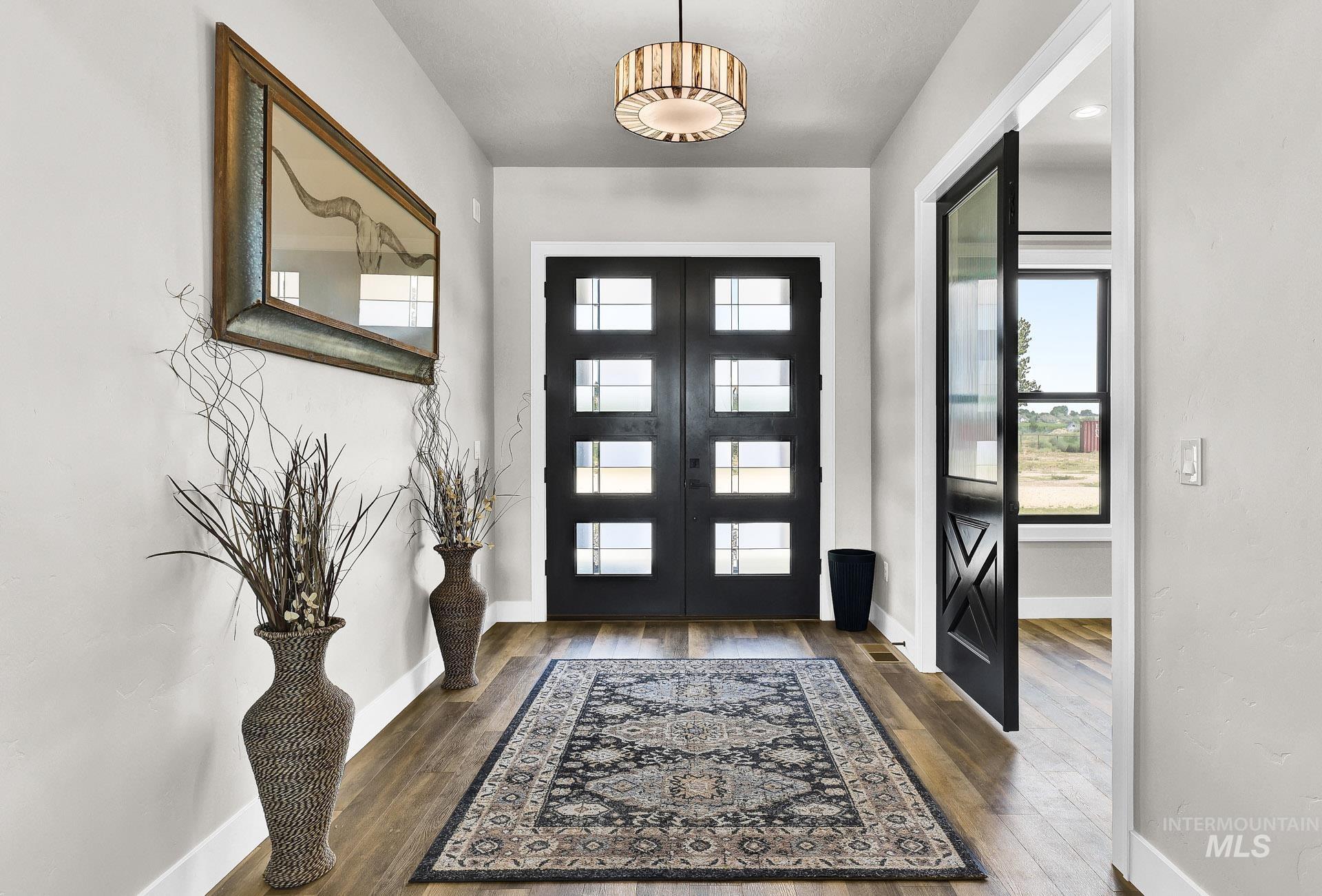 Entrance foyer featuring dark wood-style flooring and french doors