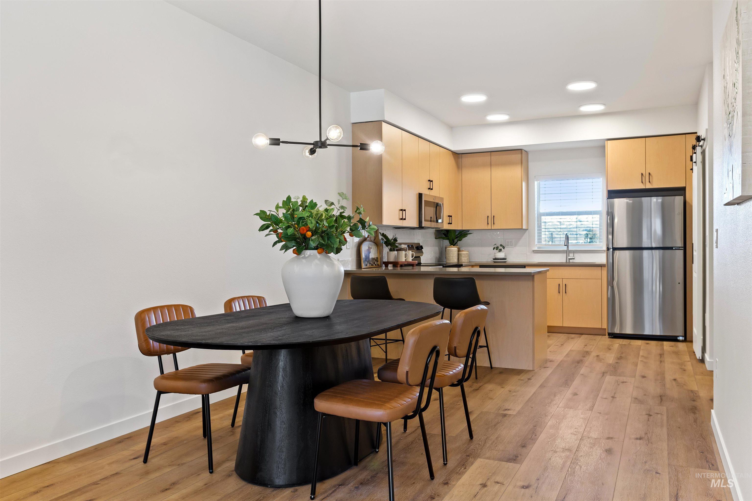 Dining area featuring light wood finished floors, a chandelier, and recessed lighting