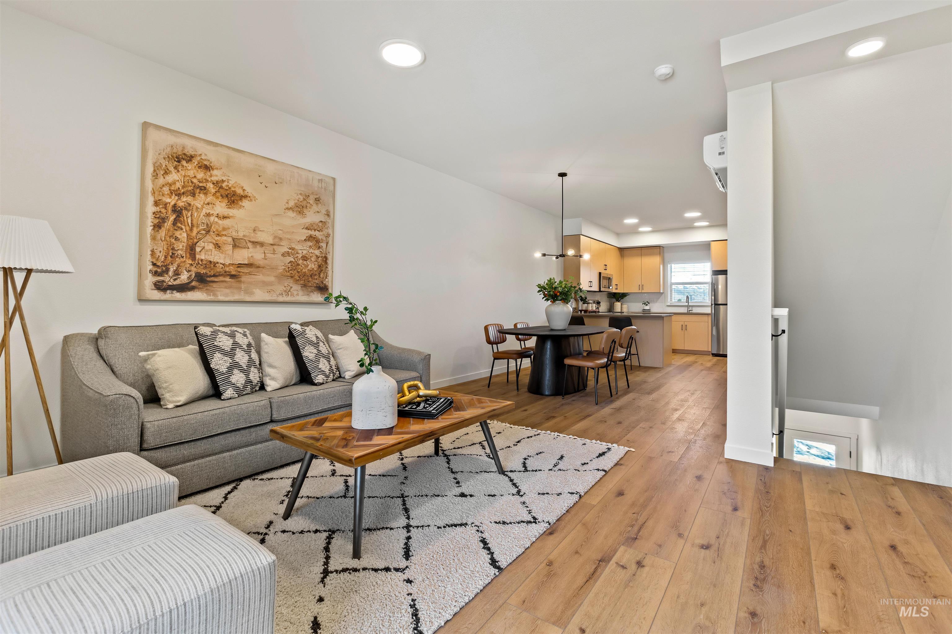 Living area with light wood-style floors and recessed lighting
