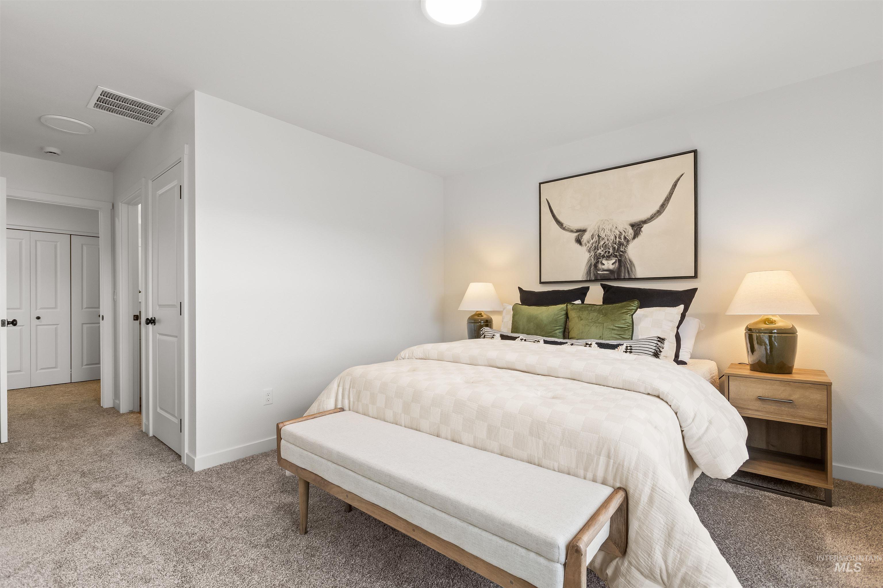 Bedroom with light colored carpet and baseboards