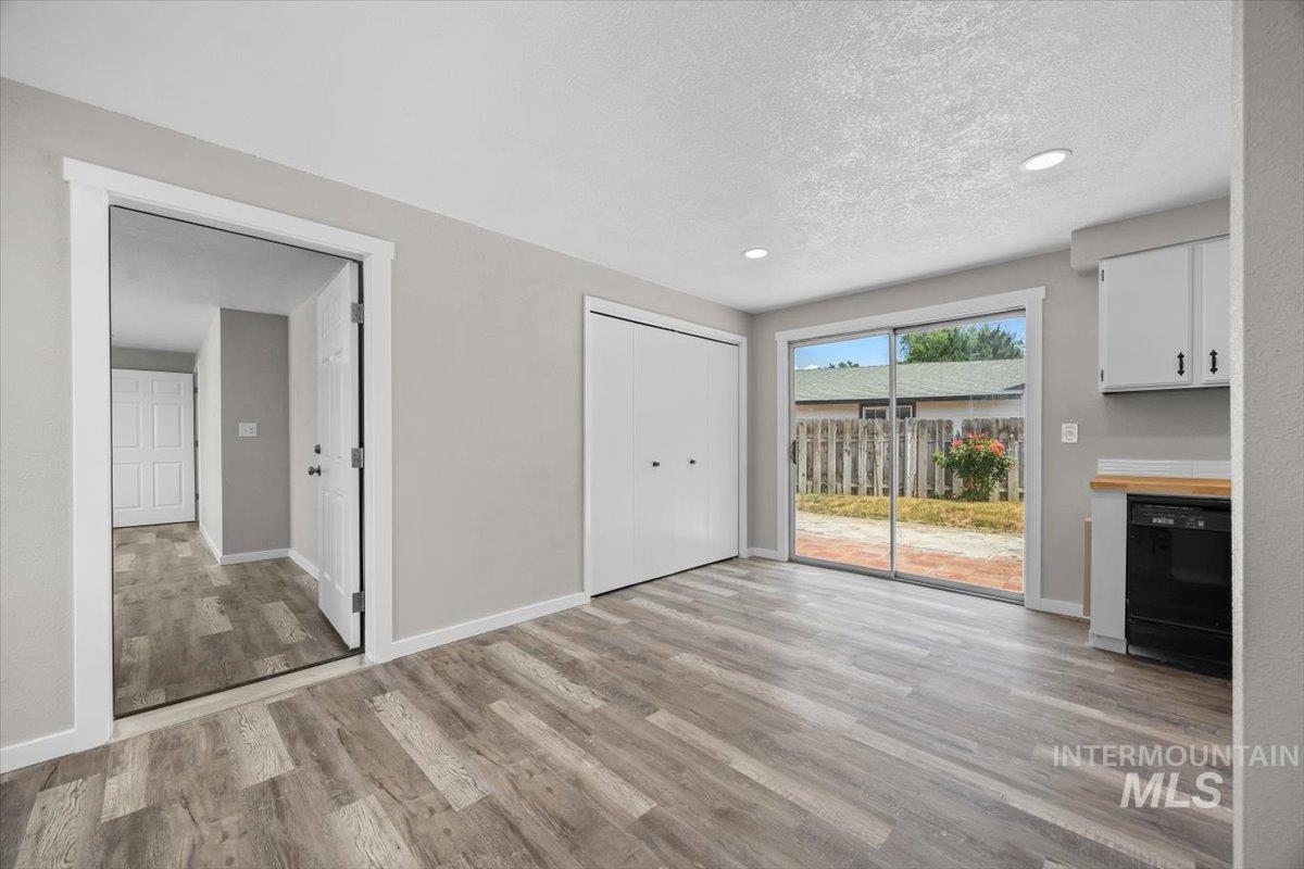 Unfurnished dining area with light wood-type flooring, recessed lighting, and a textured ceiling